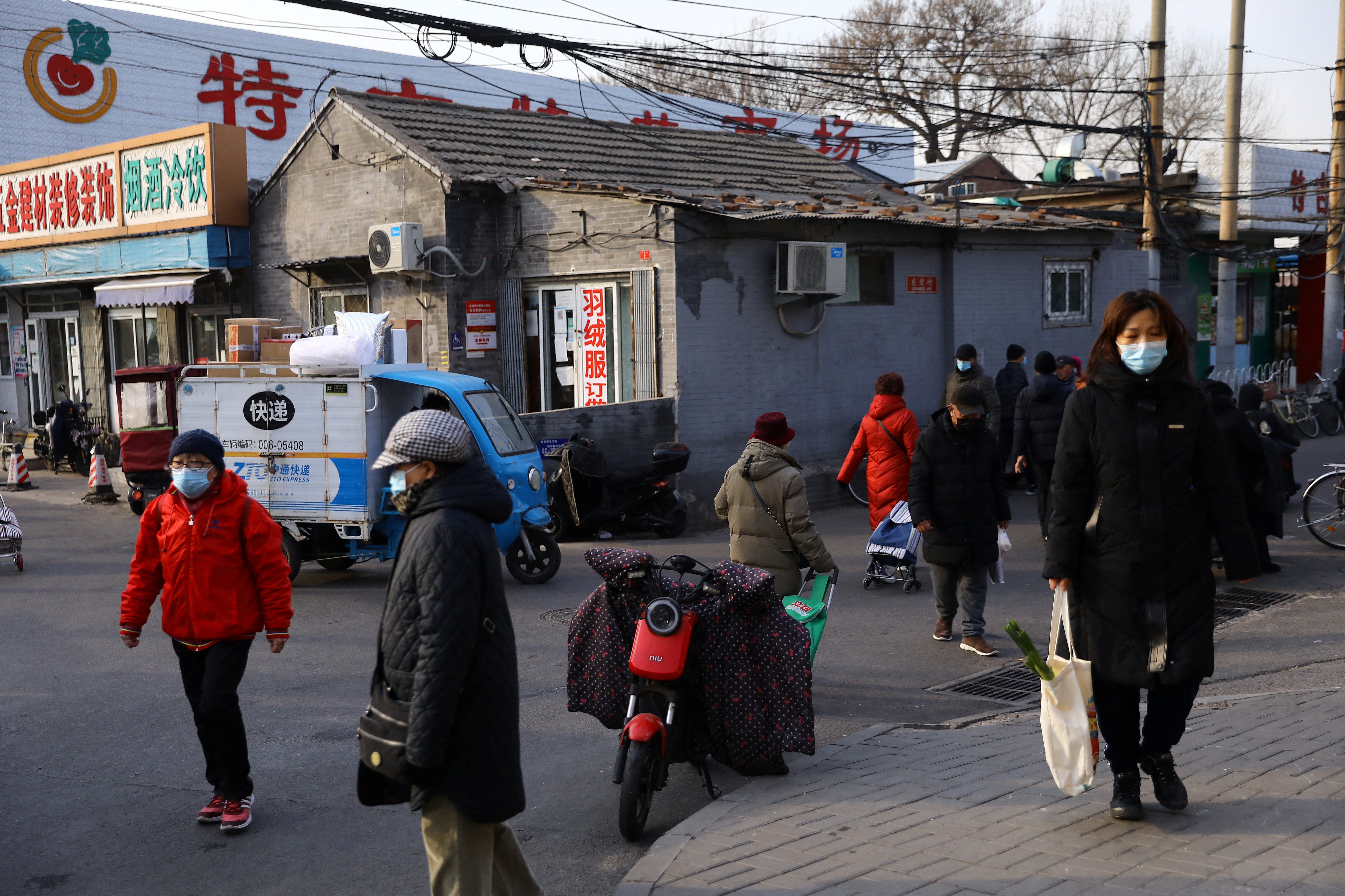 People walk on a street, as the coronavirus disease (COVID-19) pandemic continues in the country, in Beijing, China January 14, 2022. REUTERS/Tingshu Wang