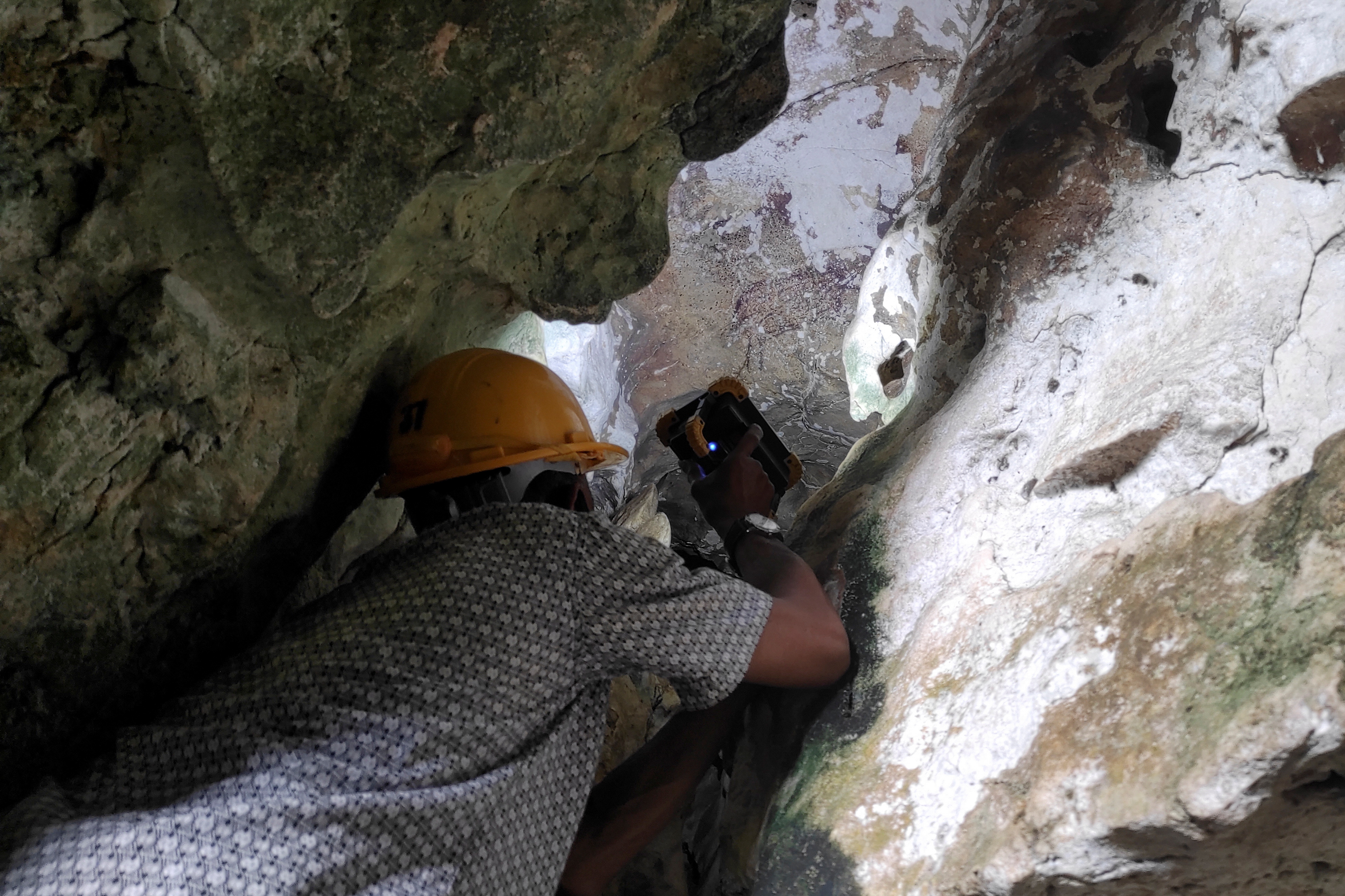 Archeologists inspect world's oldest limestone cave painting decaying due to climate change, in Maros regency