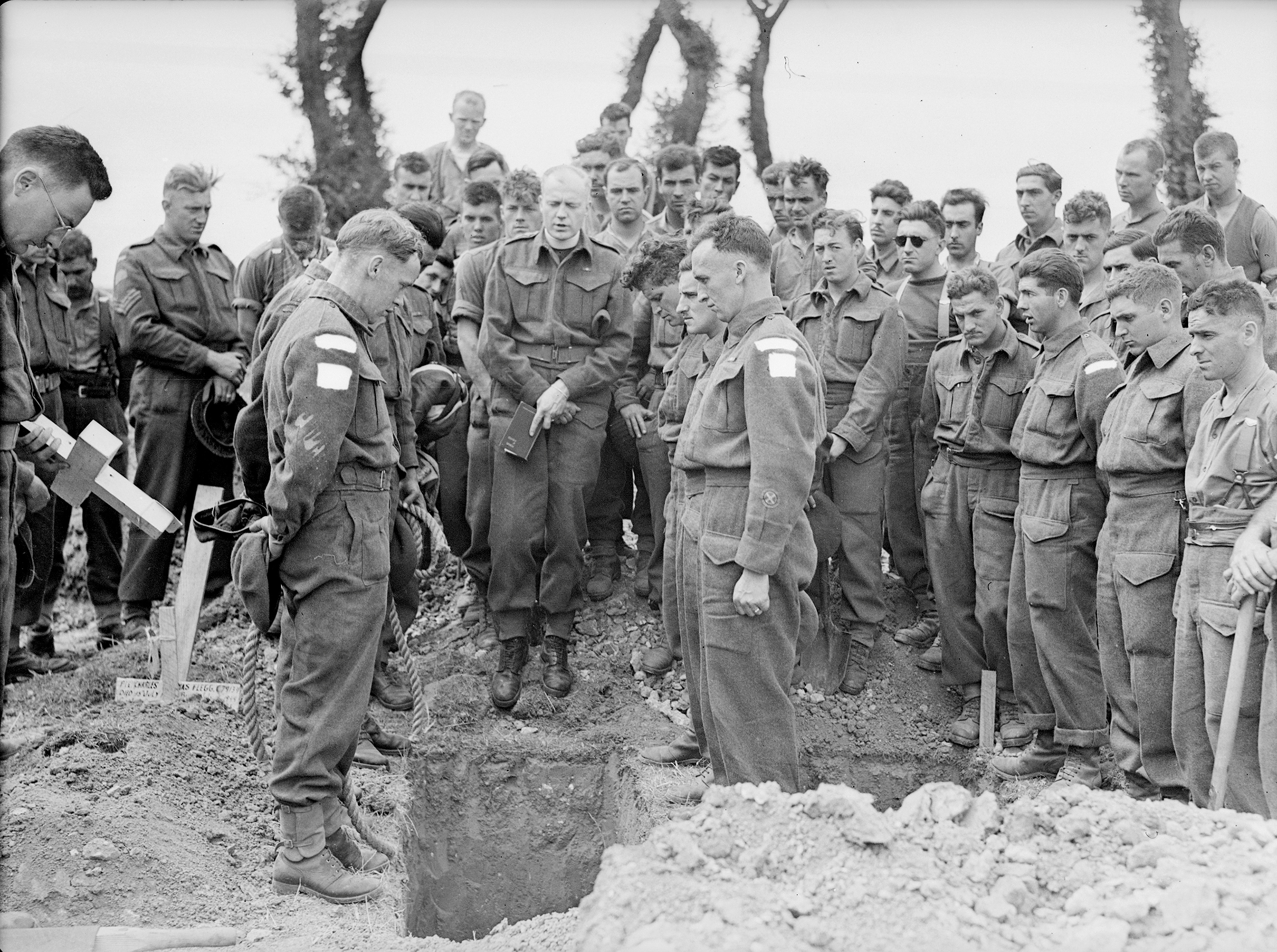 H/Captain Callum Thompson, a Canadian chaplain, conducts a funeral service at the bridgehead in Normandy