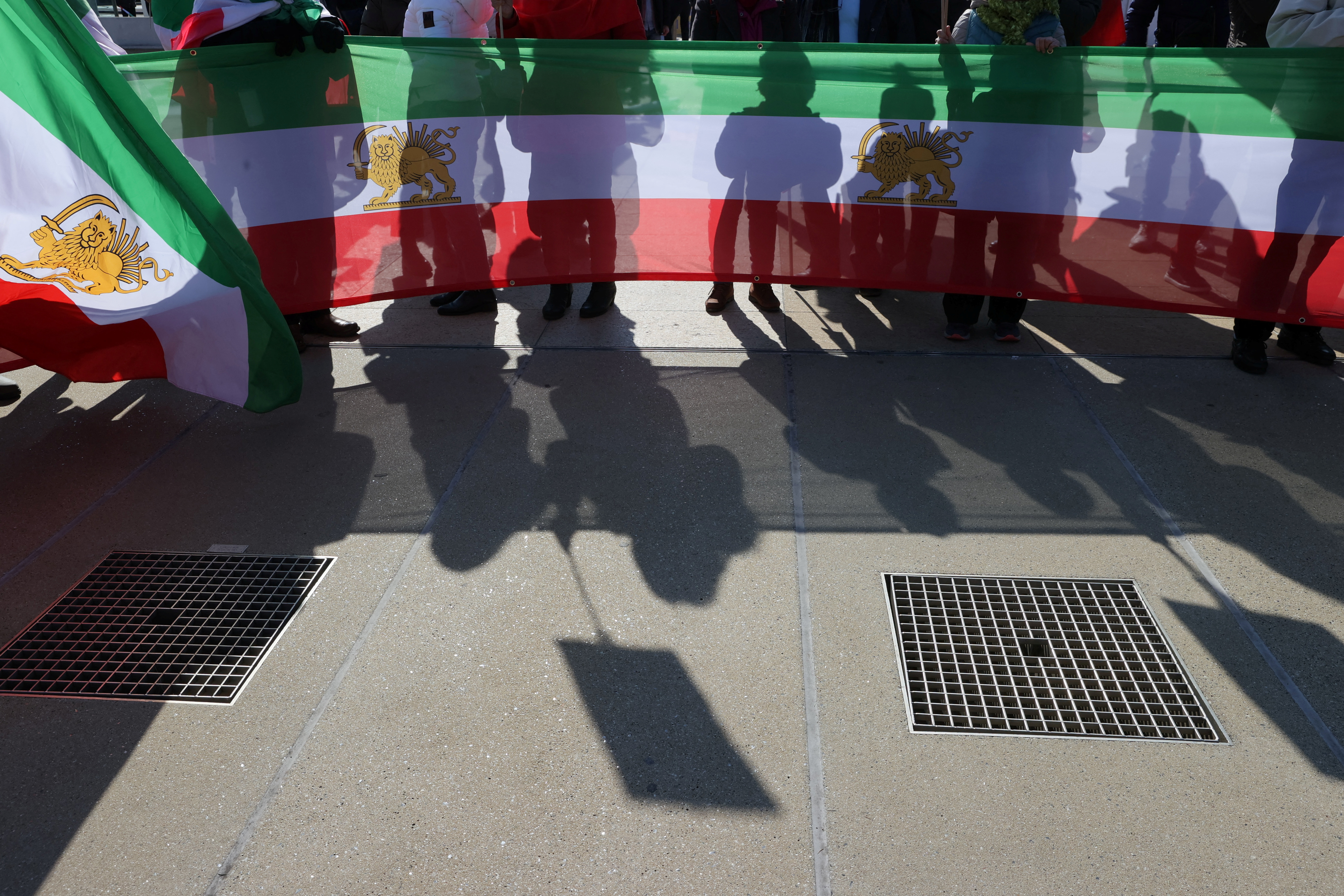 People hold flags during a demonstration against the Republic of Iran during the Human Rights Council at the United Nations in Geneva