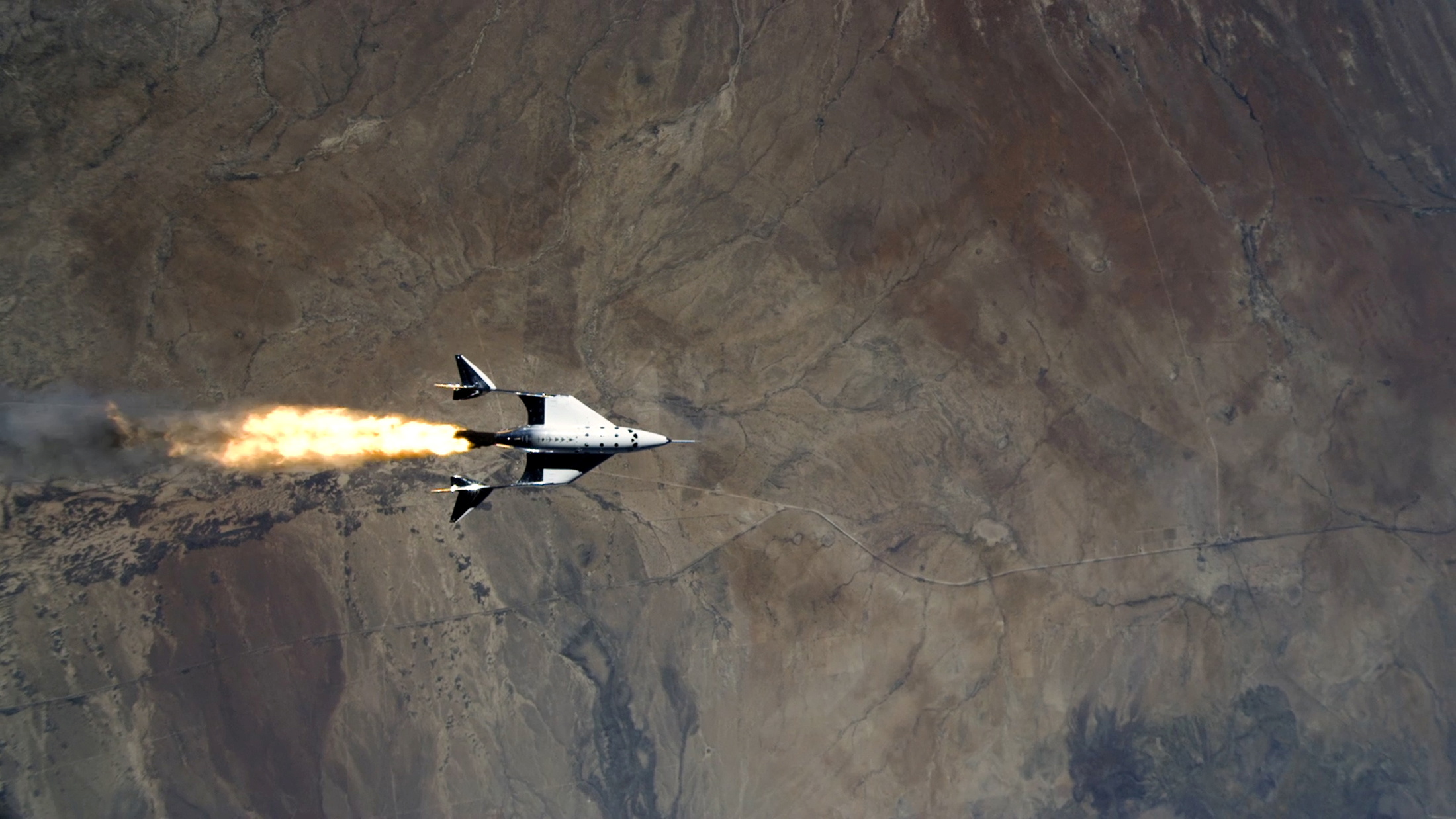 Virgin Galactic's VSS Unity, piloted by CJ Sturckow and Dave Mackay, starts its engines after release from its mothership, VMS Eve, on the way to its first spaceflight after launch from Spaceport America, New Mexico, U.S. May 22, 2021 in a still image from video. Virgin Galactic/Handout via REUTERS.