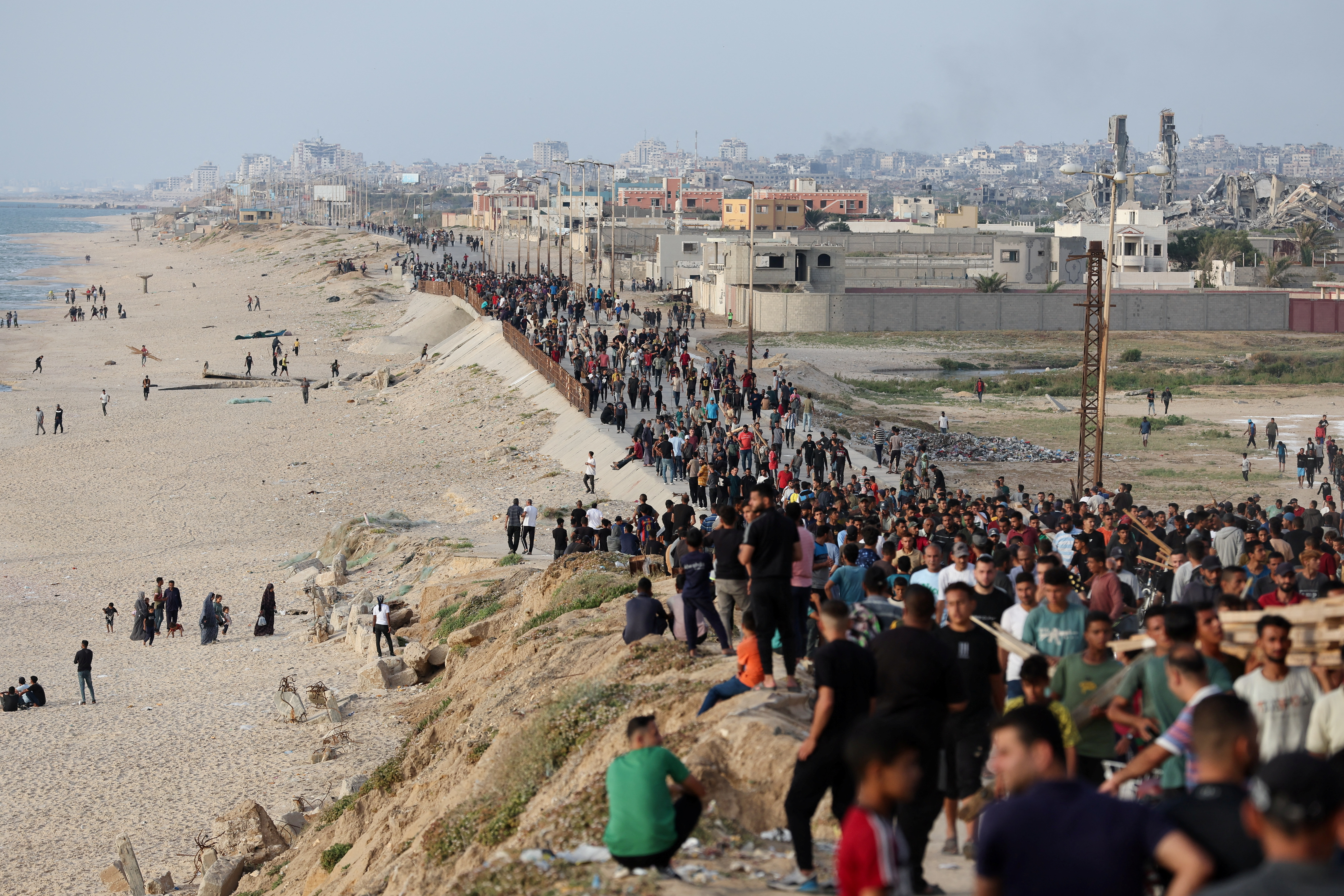 Palestinians gather in the hope of obtaining aid delivered into Gaza through a U.S.-built pier, as seen from central Gaza Strip