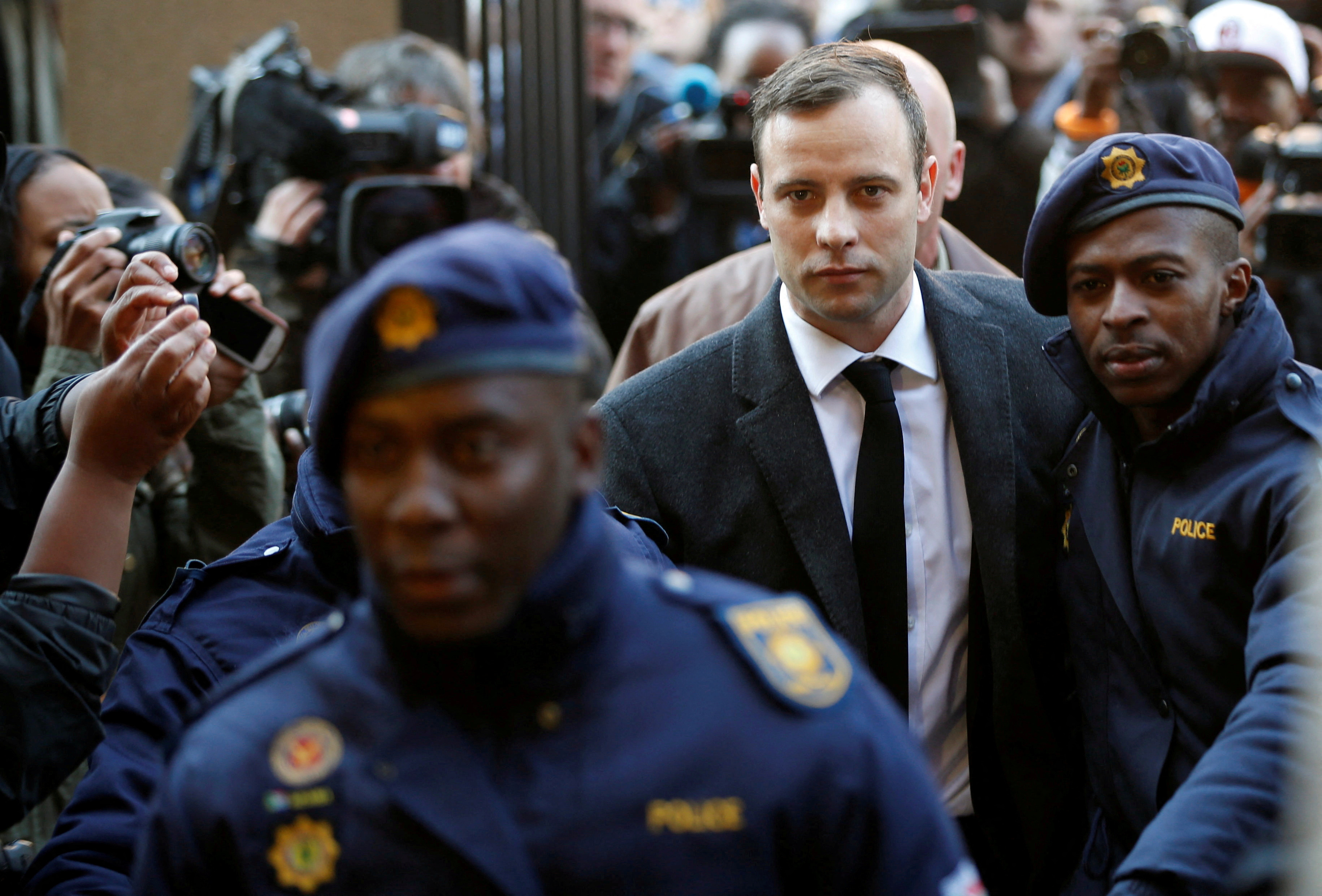 Olympic and Paralympic track star Oscar Pistorius is escorted by police officers as he arrives for his sententencing for the 2013 murder of his girlfriend Reeva Steenkamp, at North Gauteng High Court in Pretoria