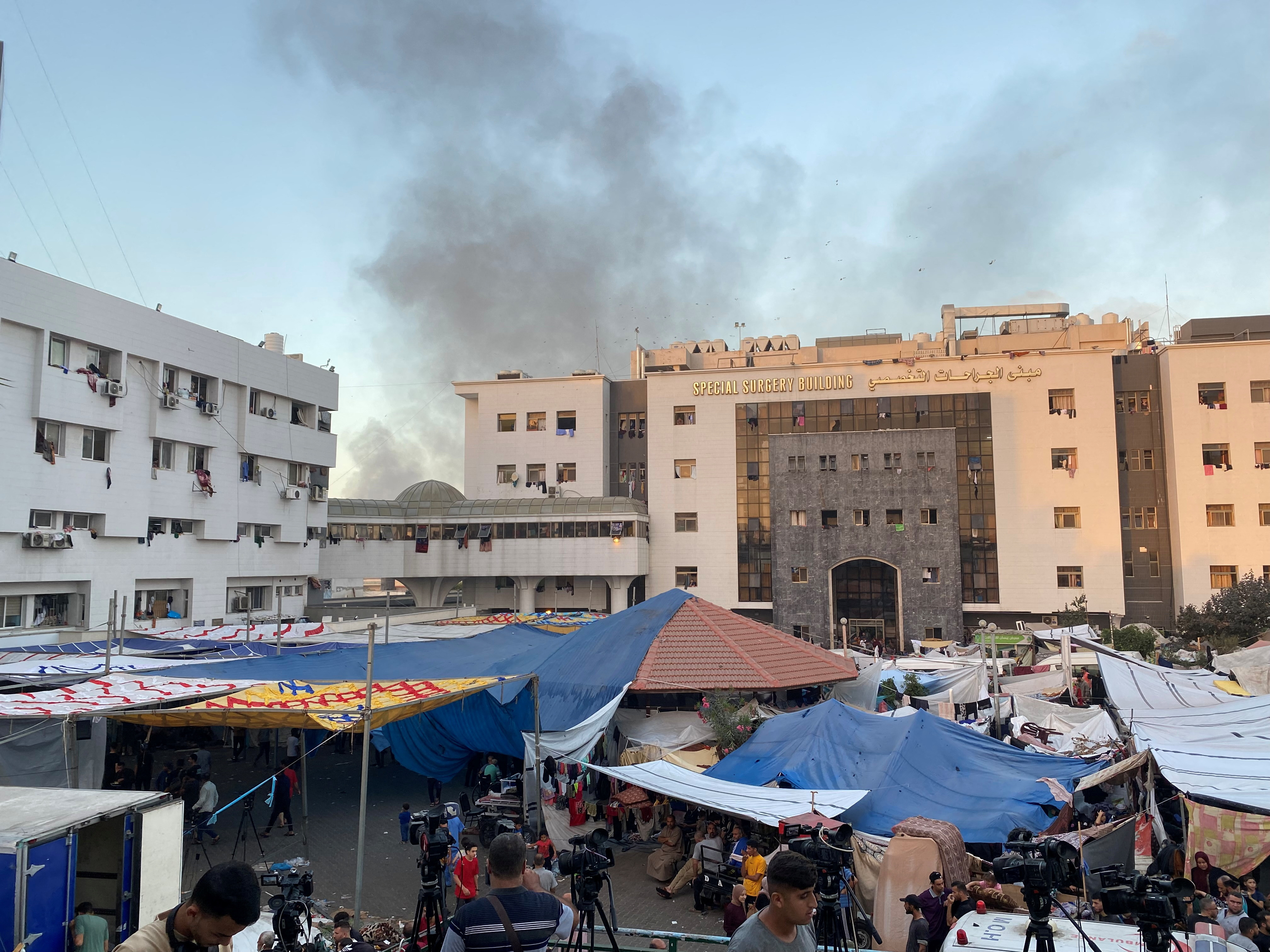 Smoke rises as displaced Palestinians take shelter at Al Shifa hospital, amid the ongoing conflict between Hamas and Israel, in Gaza City
