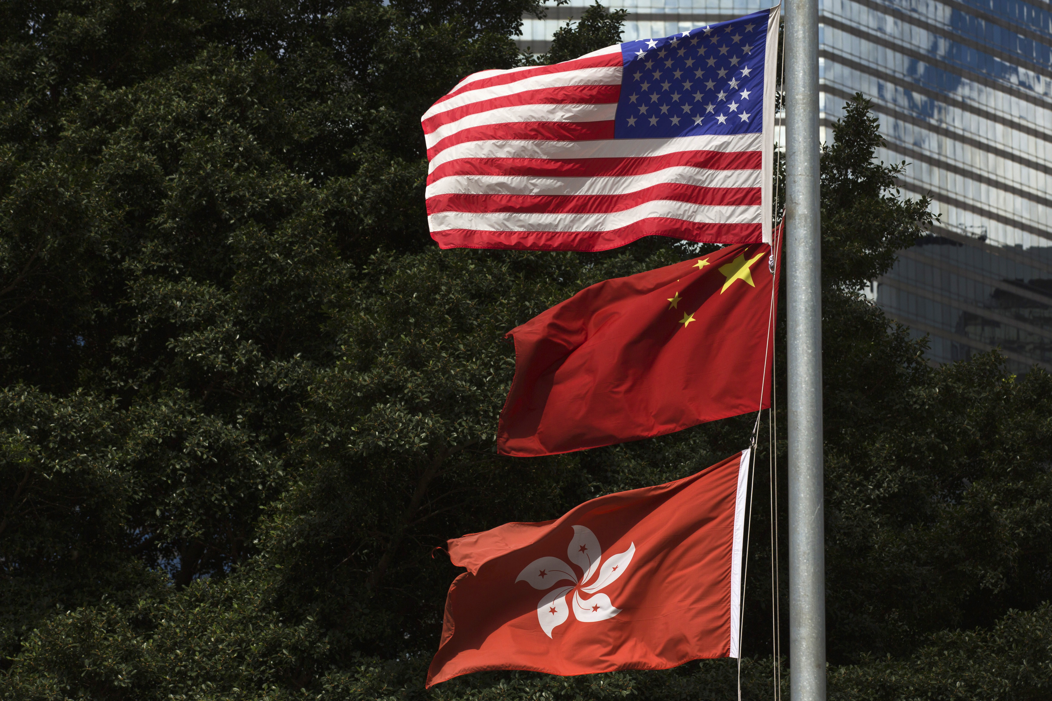 Flags of China, Hong Kong and the U.S. fly next to each other along Fenwick Pier, in Hong Kong