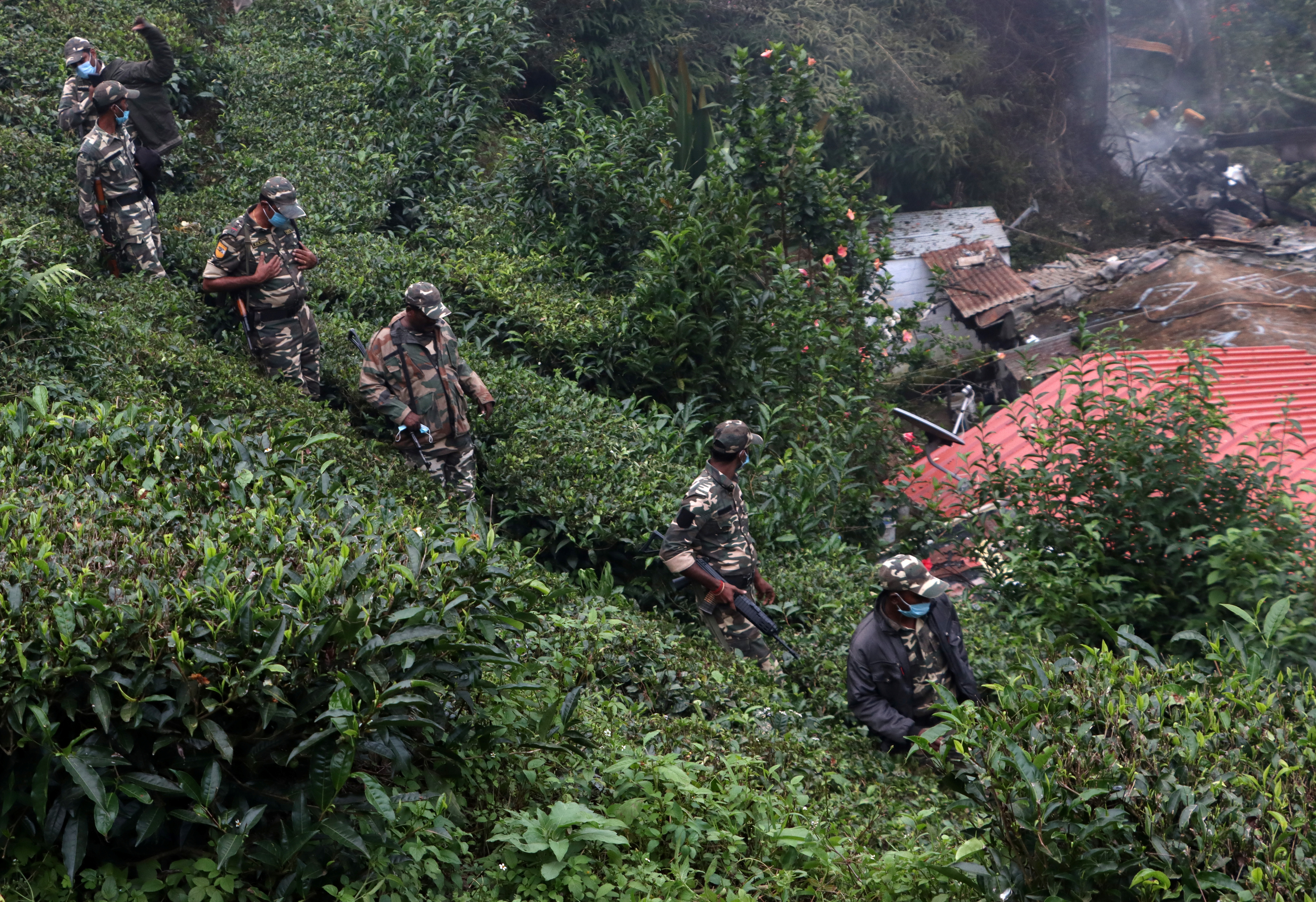 Security forces patrol past the debris of the Russian-made Mi-17V5 helicopter after it crashed near the town of Coonoor in the southern state of Tamil Nadu, India, December 8, 2021. REUTERS/Stringer