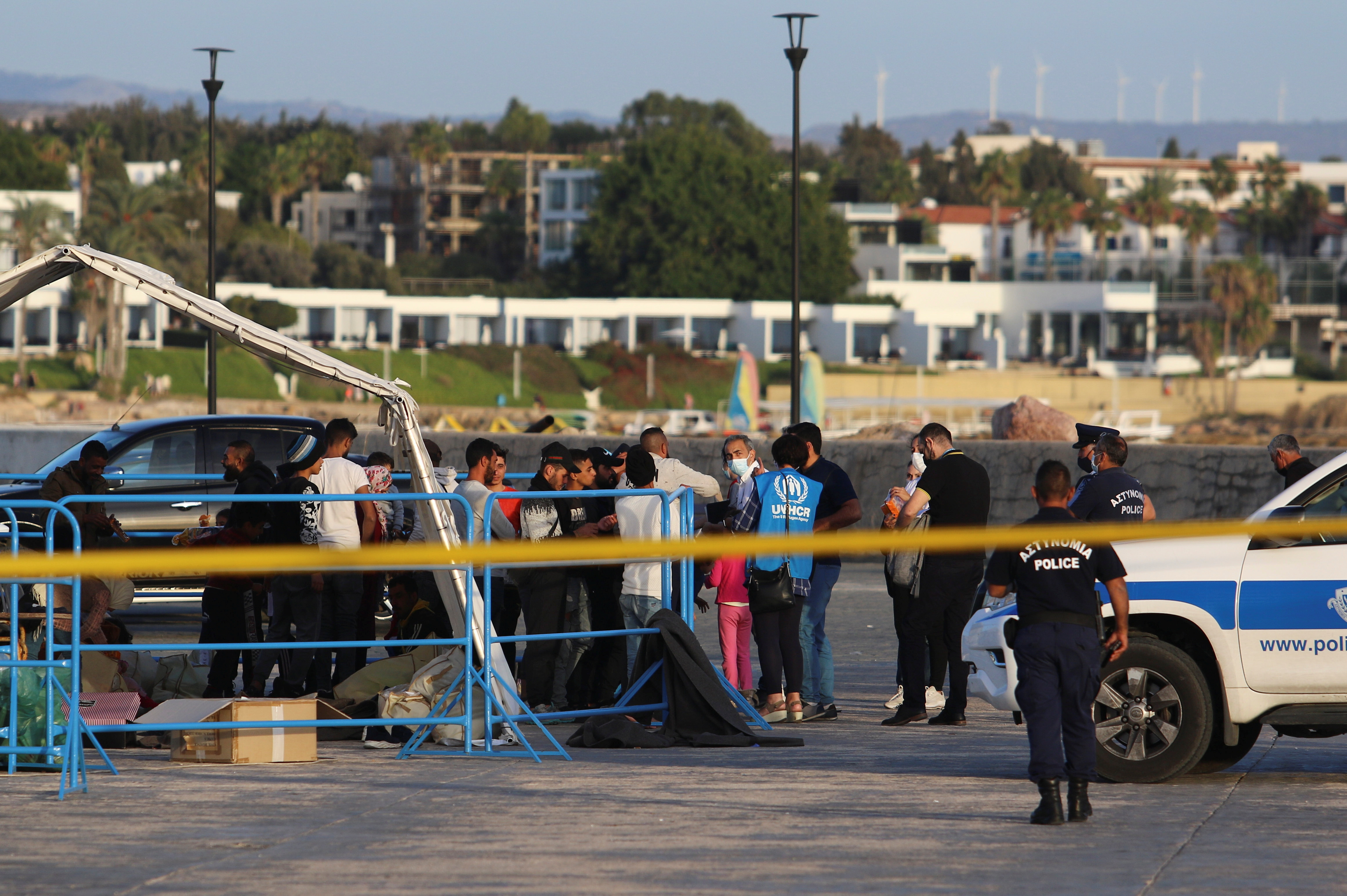 Migrants disembark from a boat in Paphos port