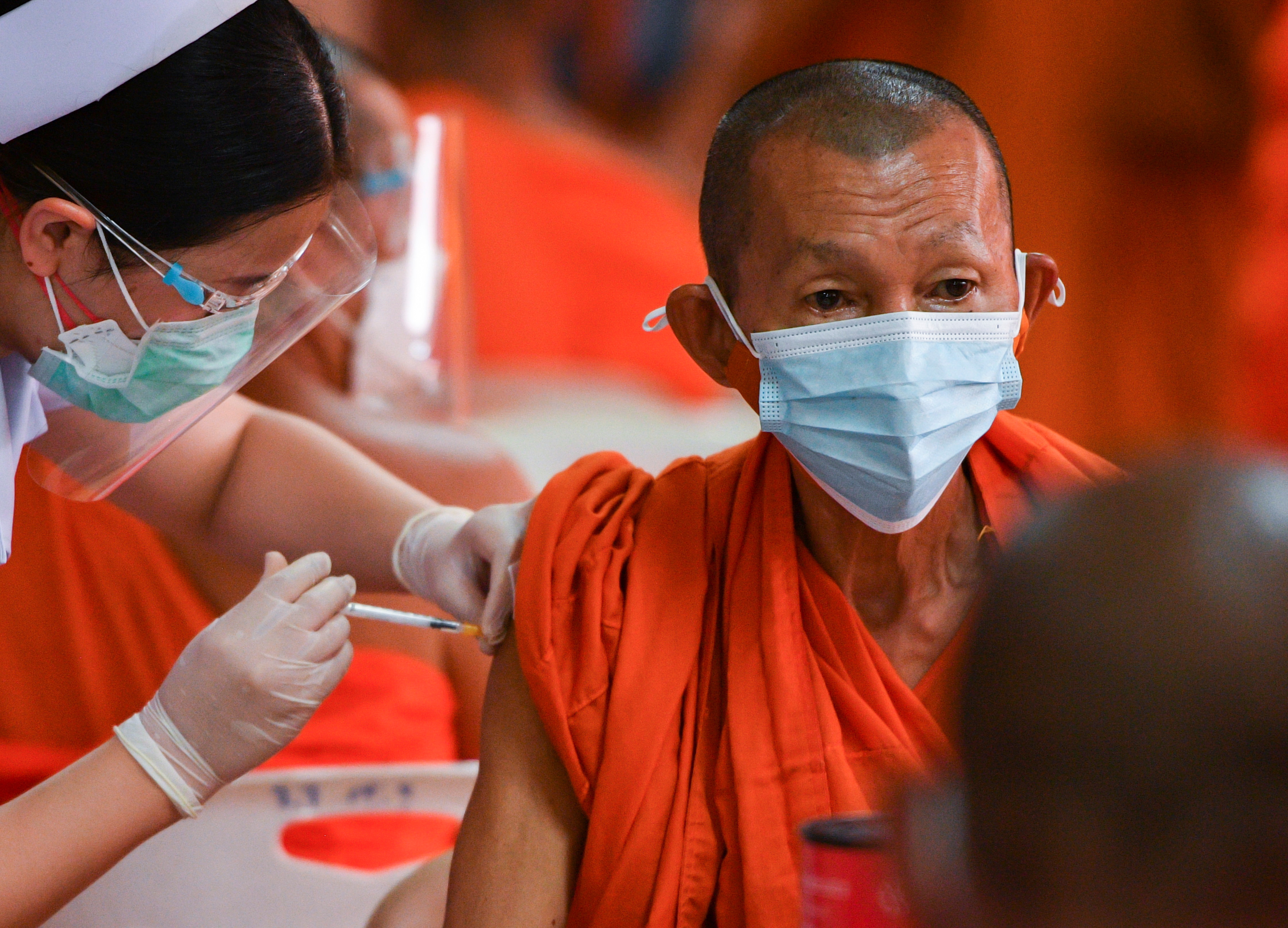 Buddhist monks receive a dose of the AstraZeneca coronavirus disease (COVID-19) vaccine in Bangkok