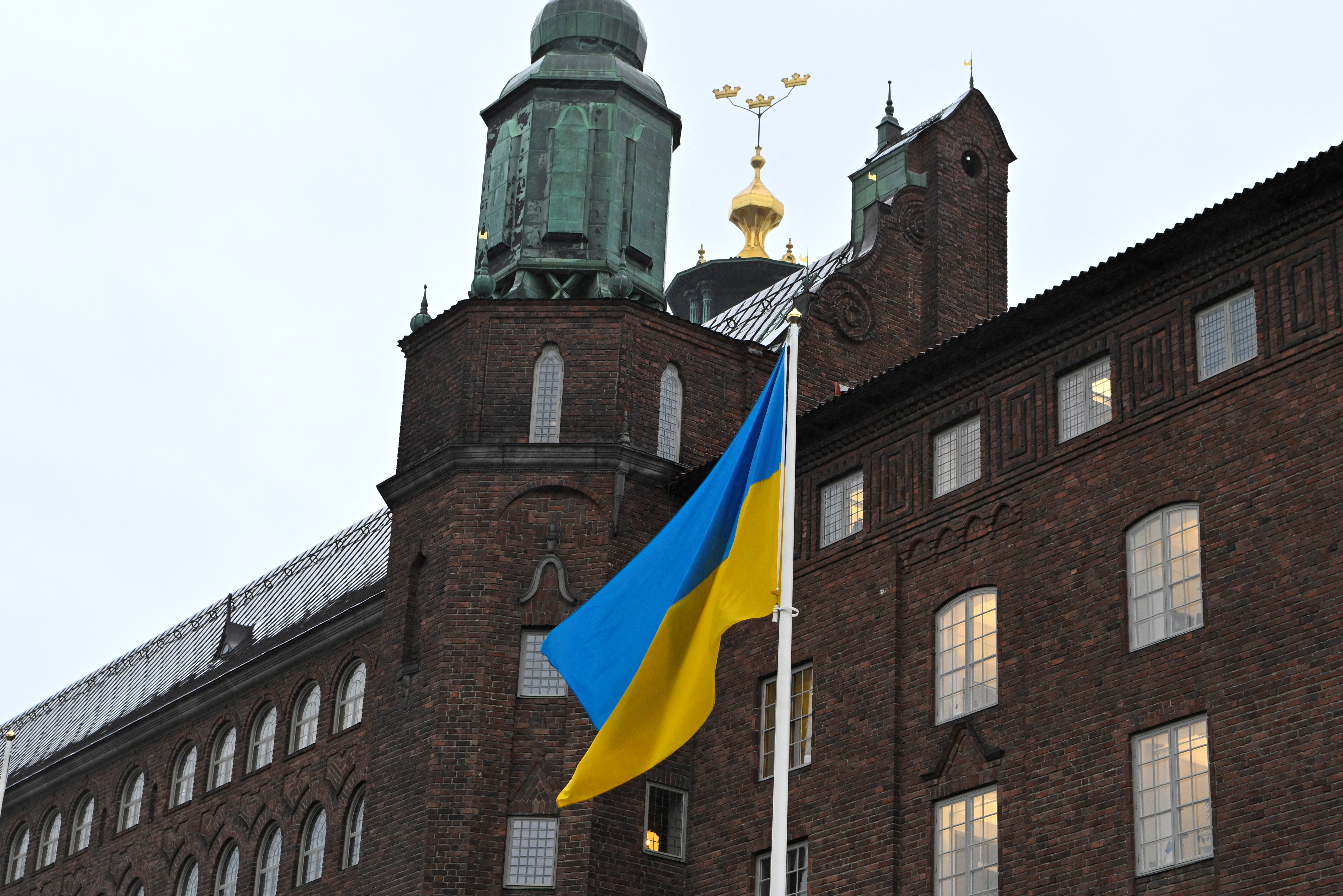The flag of Ukraine waves in the wind at City Hall, in Stockholm