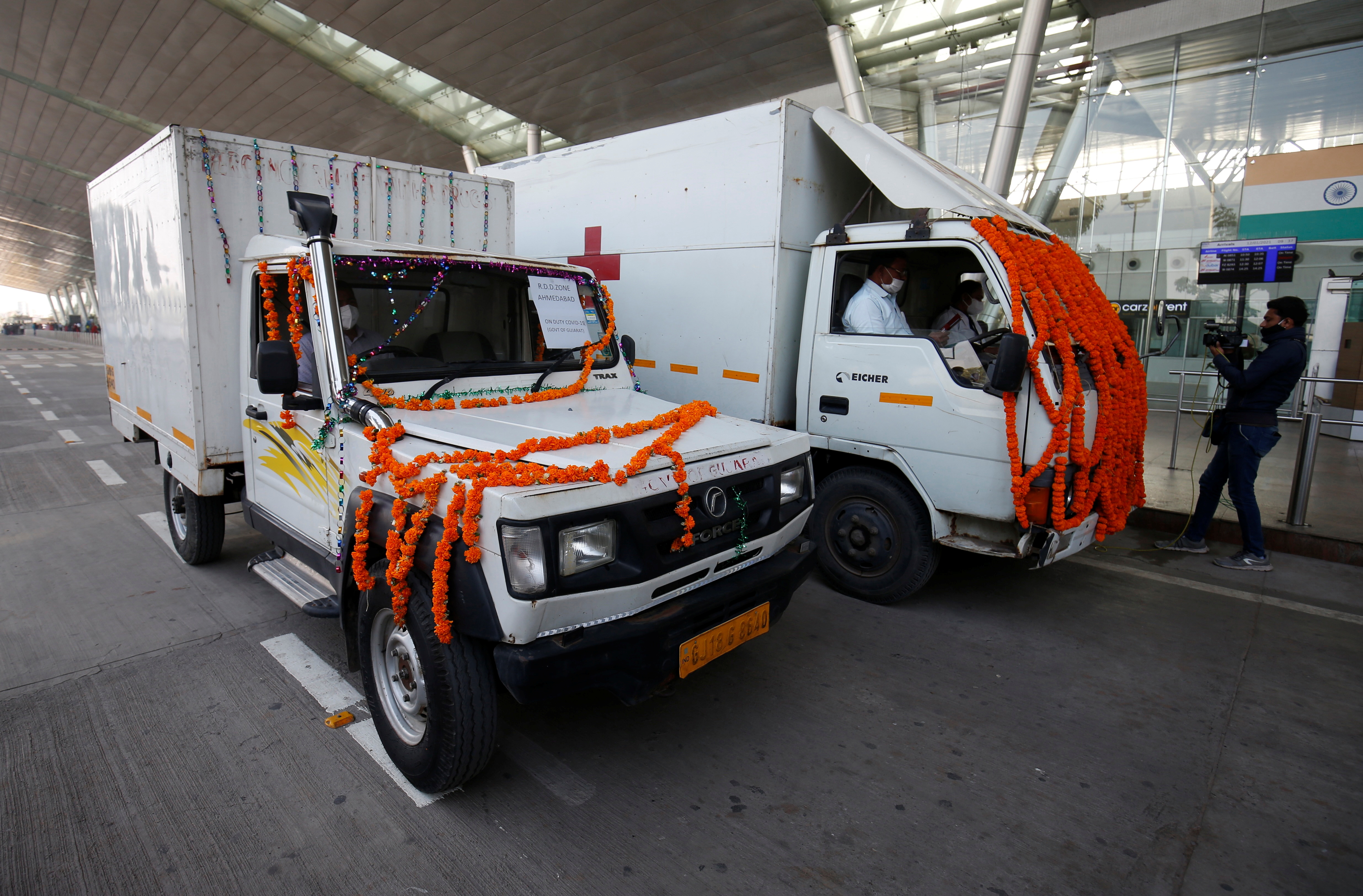 Vehicles containing COVISHIELD leave the airport after a consignment of the vaccines arrived from the western city of Pune for its distribution, in Ahmedabad