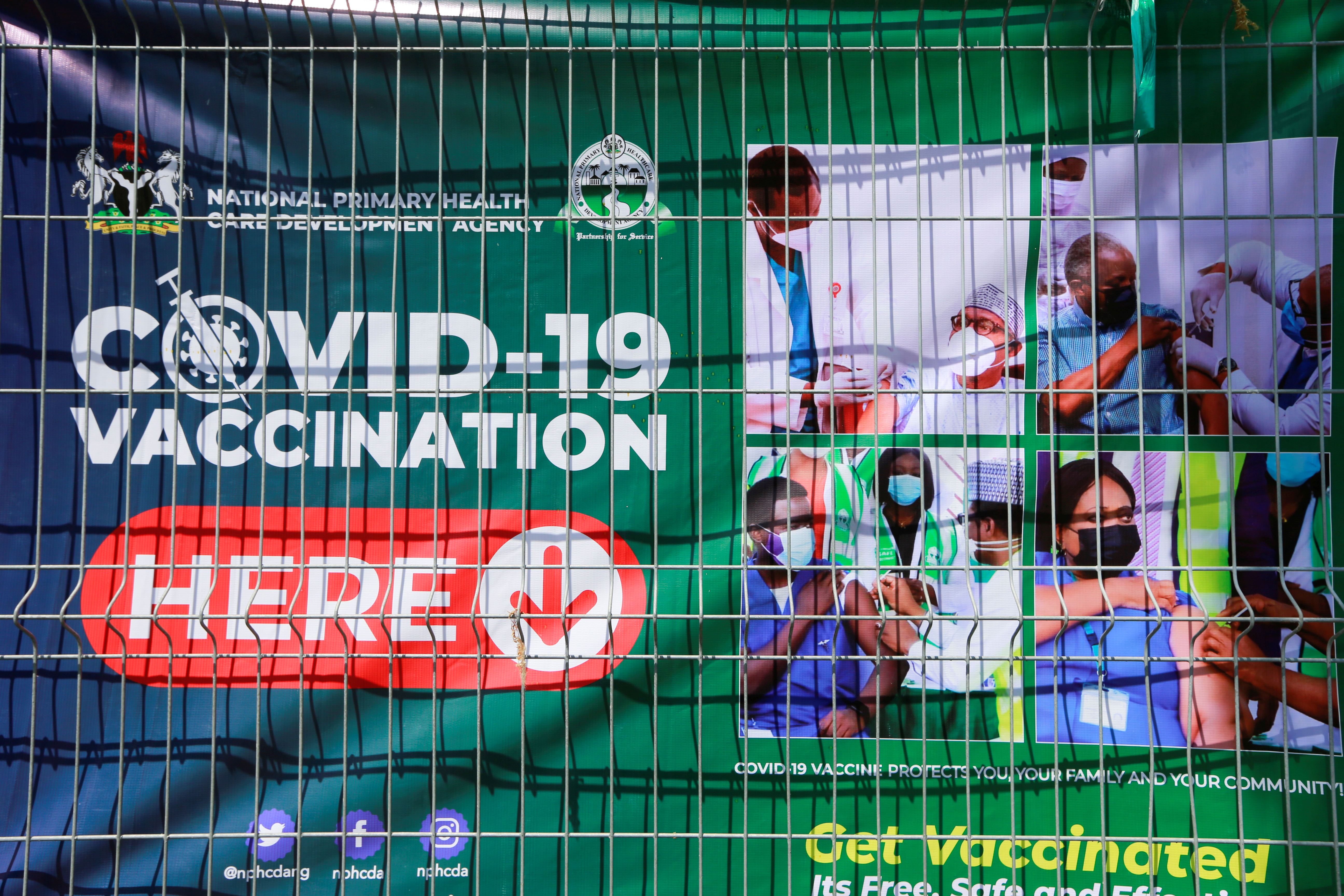 A banner is displayed on a fence at a coronavirus disease (COVID-19) vaccination centre, after the government commenced the roll out of mass vaccination in Abuja, Nigeria November 19, 2021. REUTERS/Afolabi Sotunde/Files