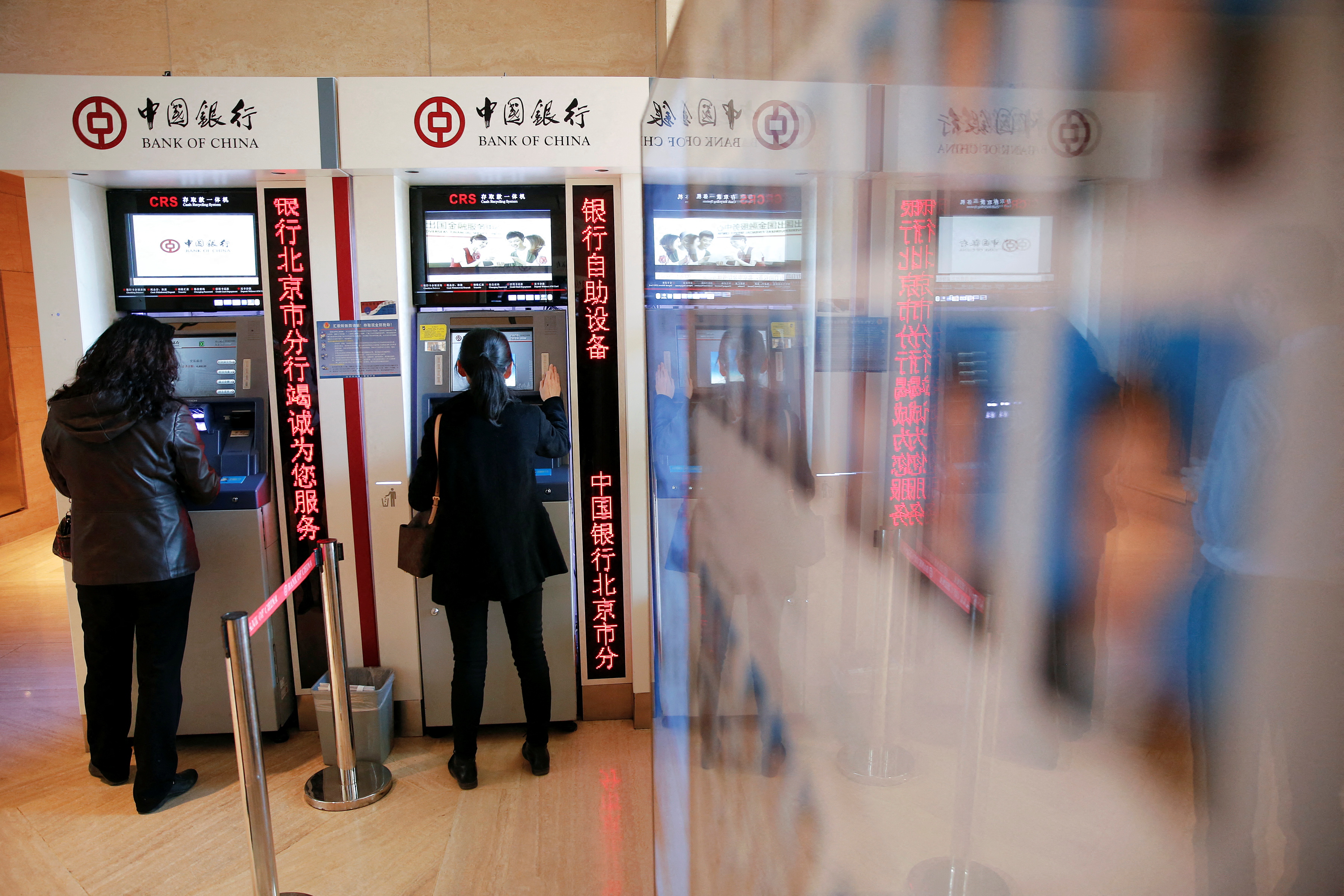 People use ATM's inside the Bank of China head office building in Beijing
