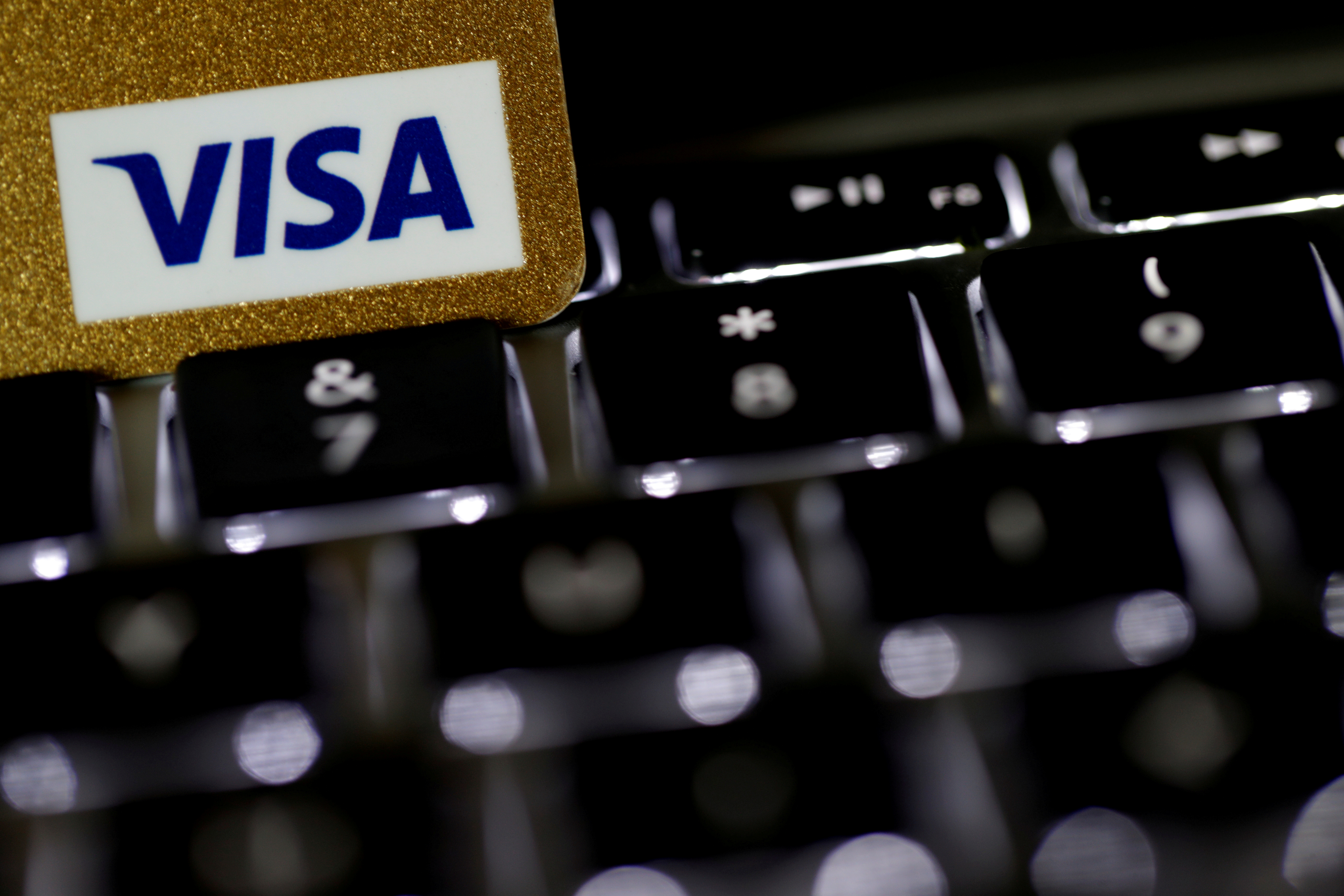 A Visa credit card is seen on a computer keyboard in this picture illustration