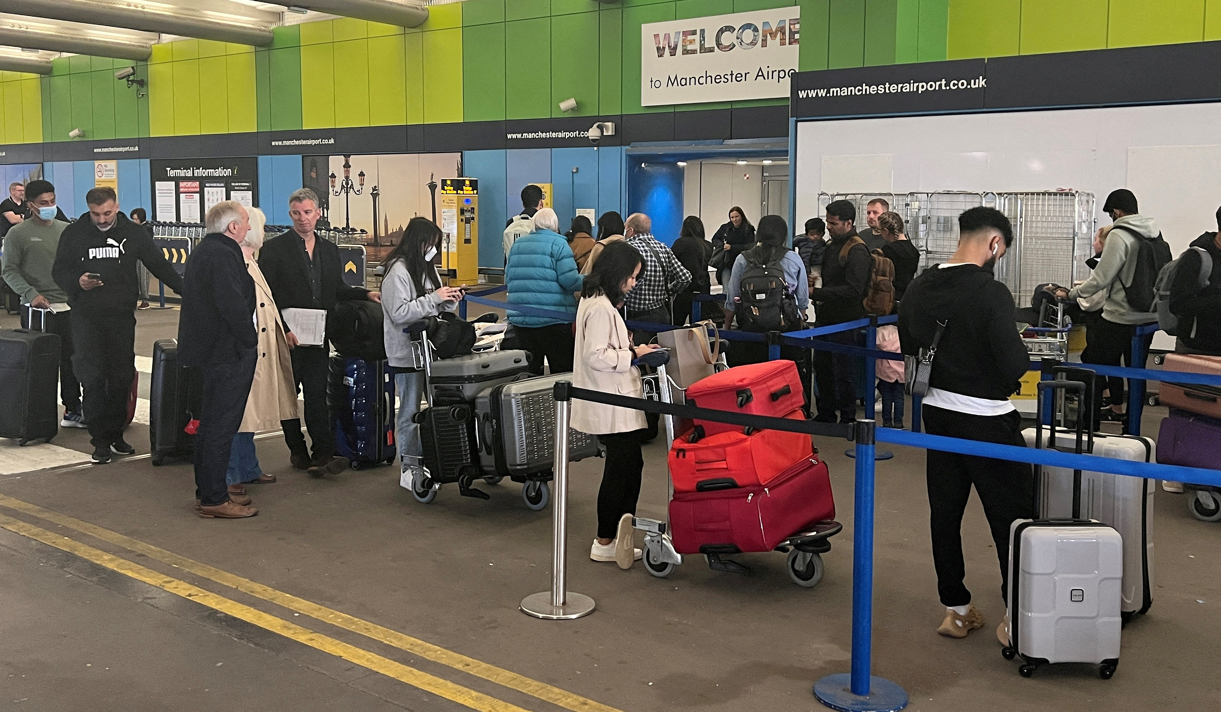 Passengers queue for check in outside Terminal 1 at Manchester Airport