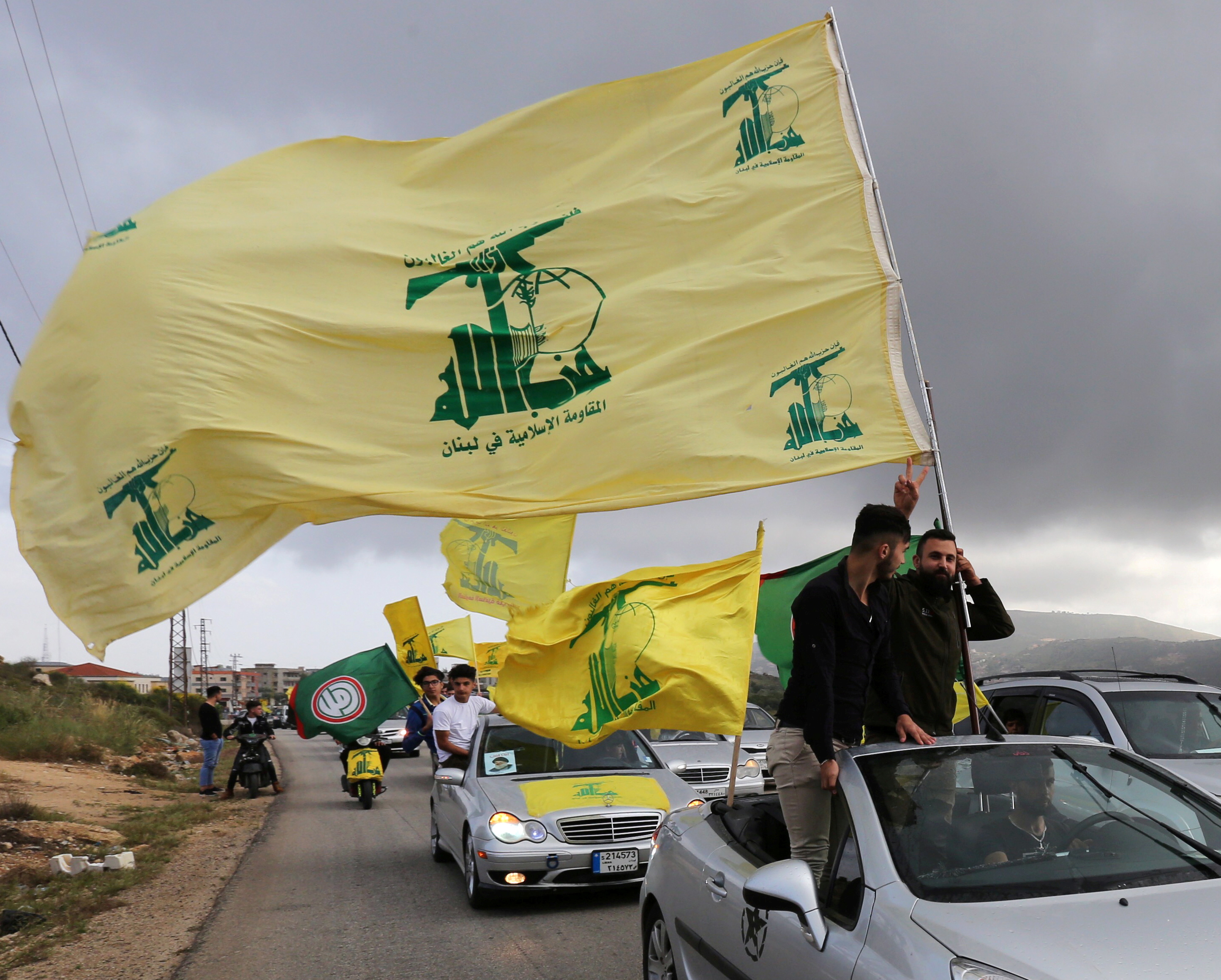 A supporter of Lebanon's Hezbollah gestures as he holds a Hezbollah flag in Marjayoun