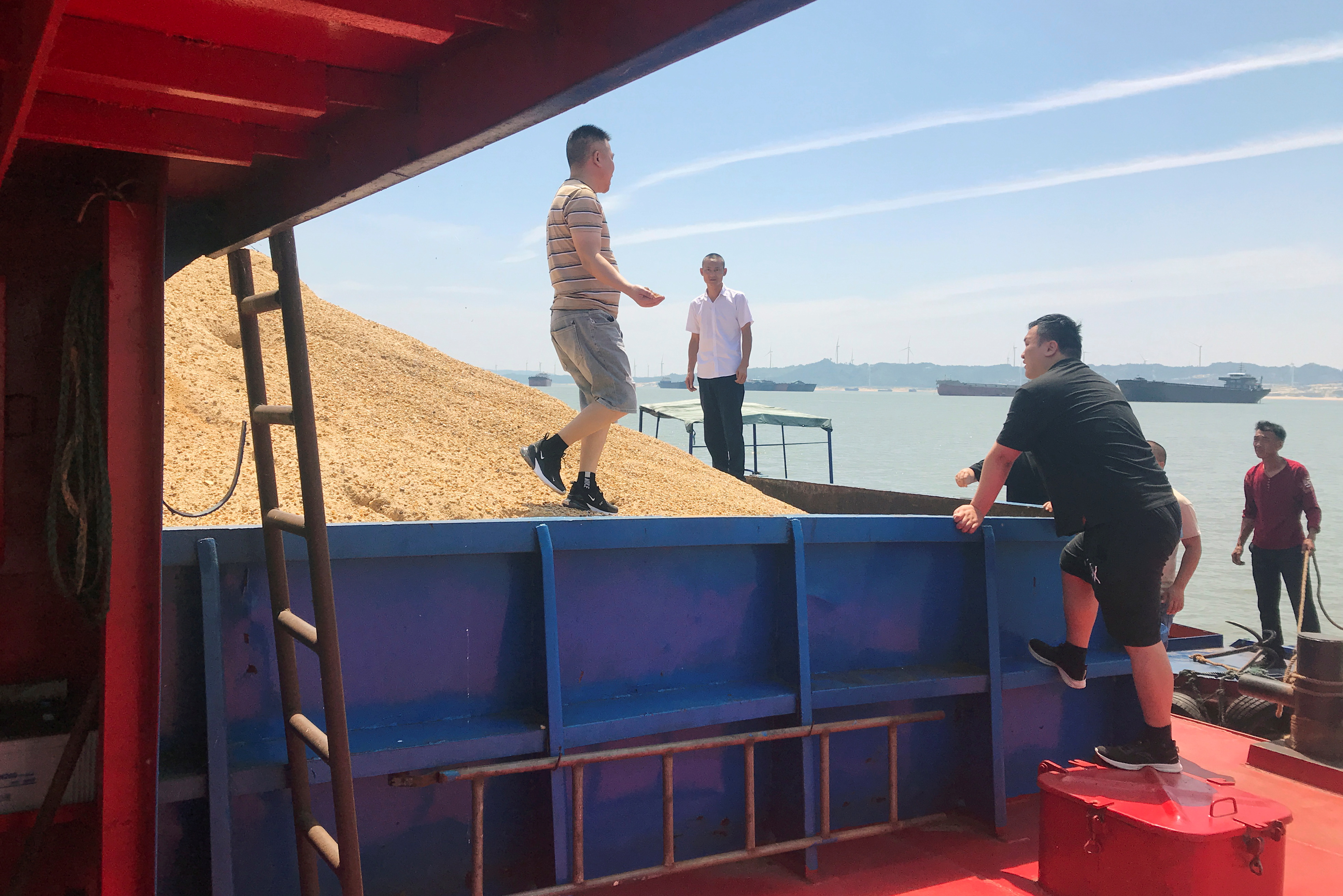 Assessors inspect sand on barges on Poyang Lake in Jiujiang