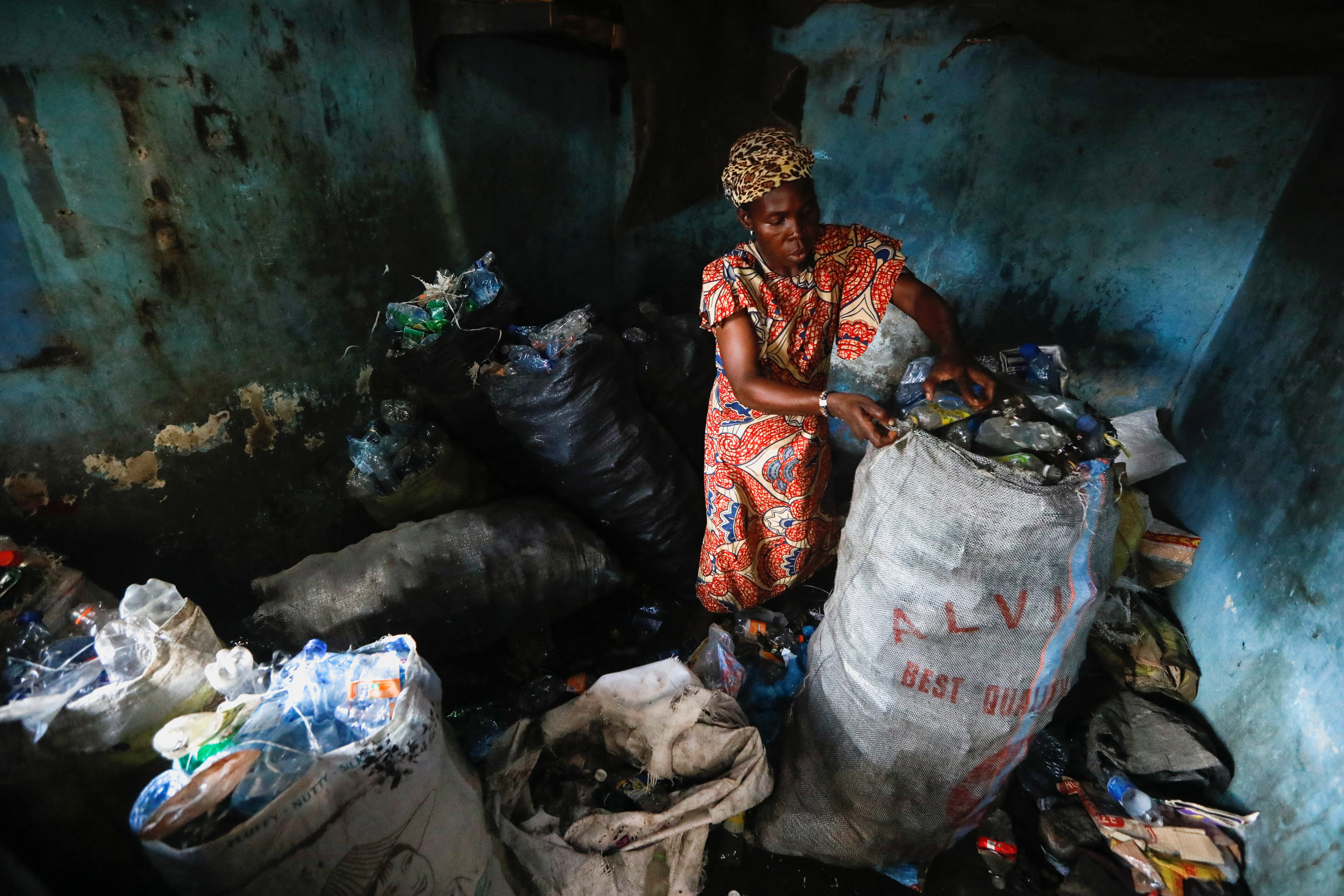 Fatimoh Adeosun, de 48 años, padre de un estudiante de My Dream Stead, clasifica los desechos plásticos para enviarlos, en Ajegunle