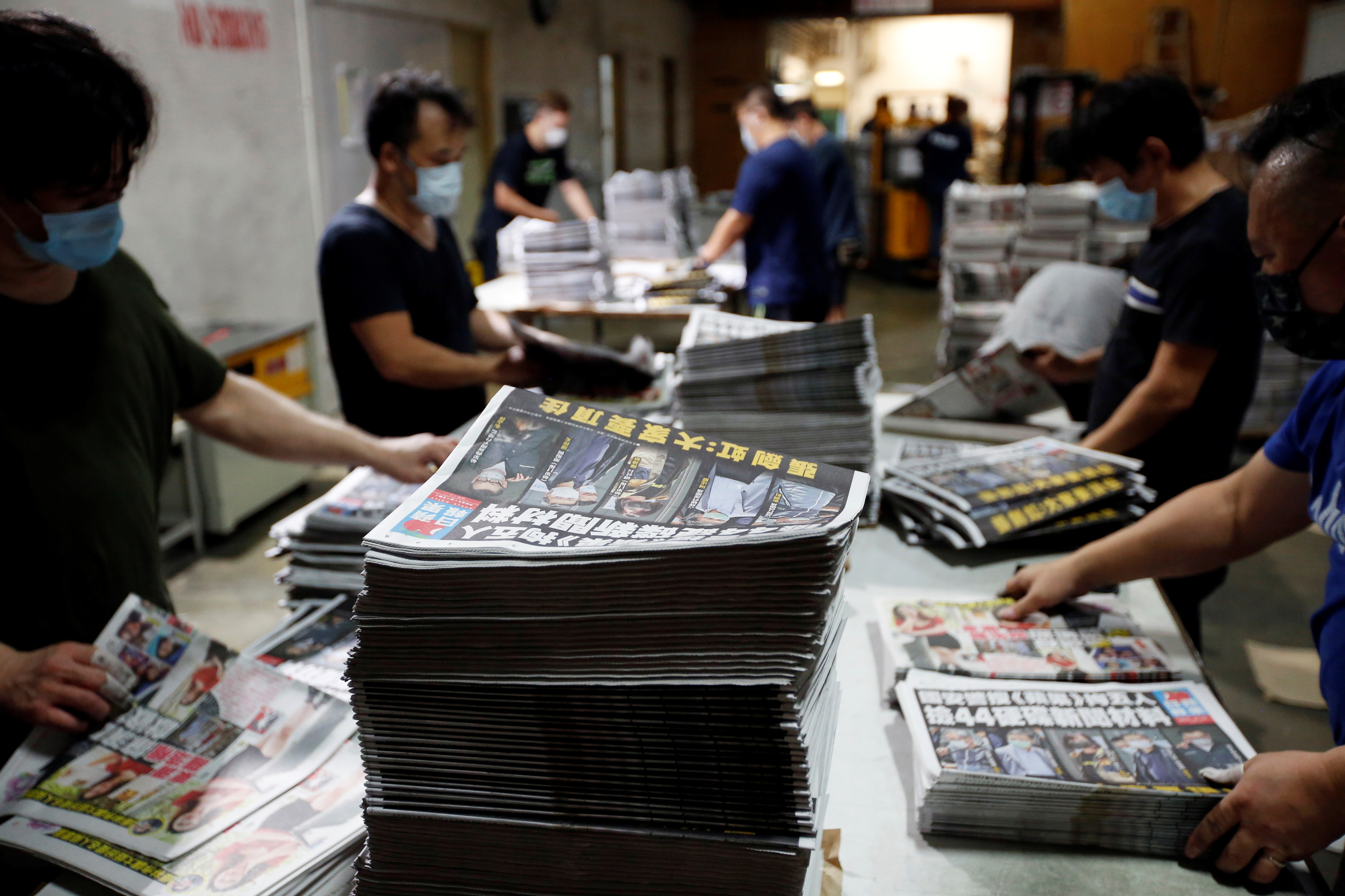 Workers prepare copies of Apple Daily newspaper at its printing facility for distribution in Hong Kong