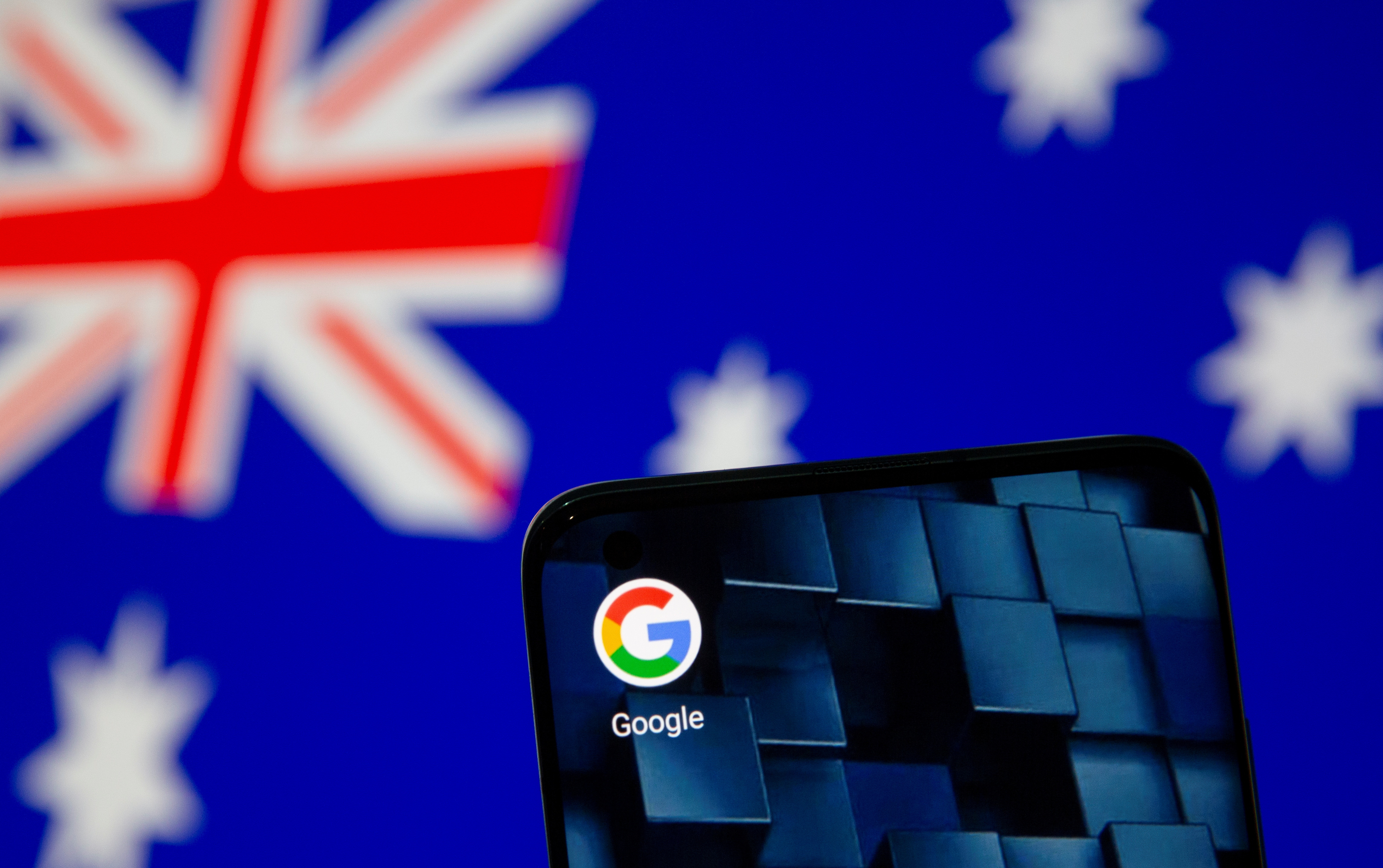 Smartphone with google app icon is seen in front of the displayed Australian flag in this illustration taken