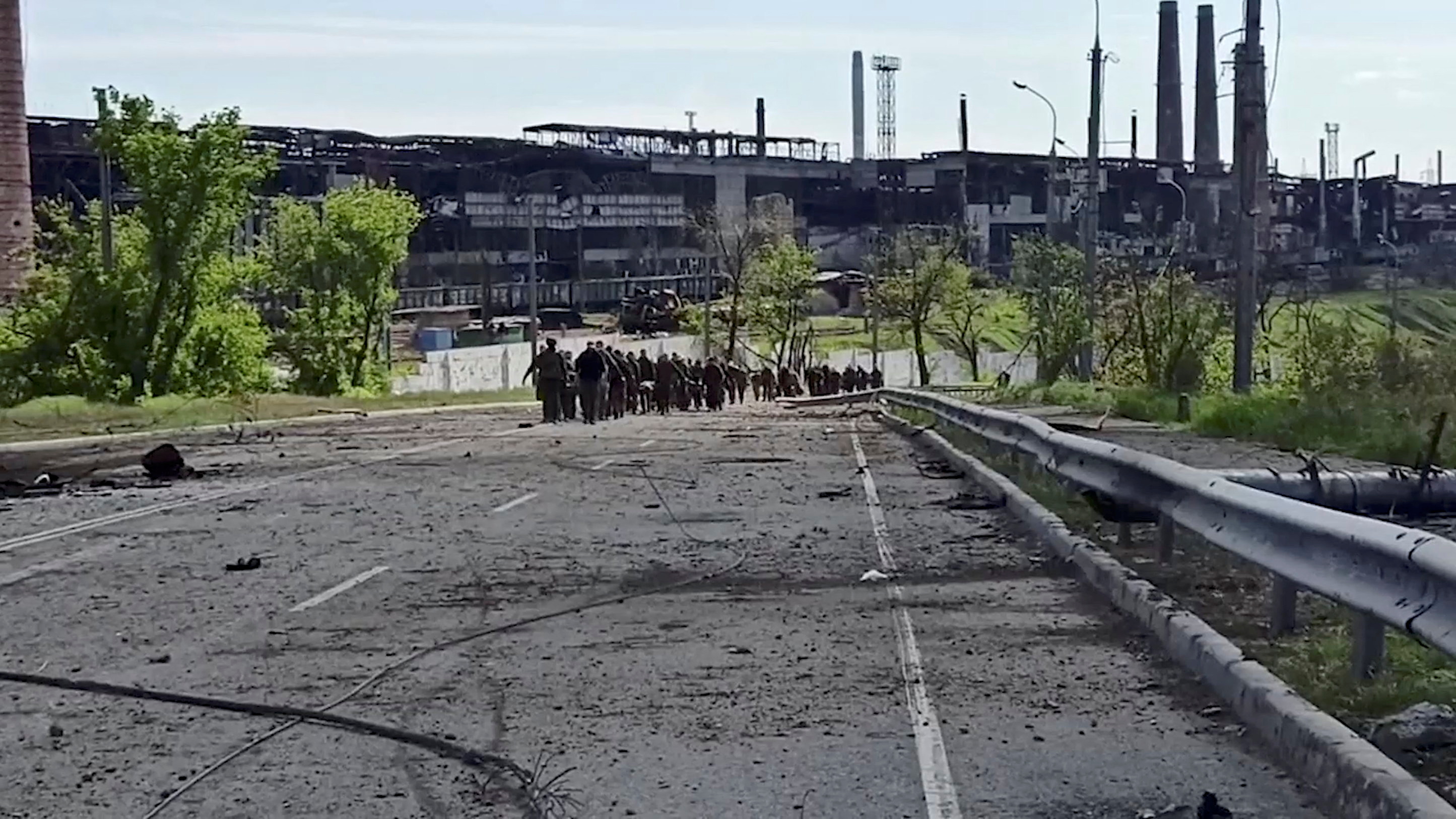 Service members of Ukrainian forces who have surrendered after weeks holed up at Azovstal steel works leave the territory of the plant in Mariupol