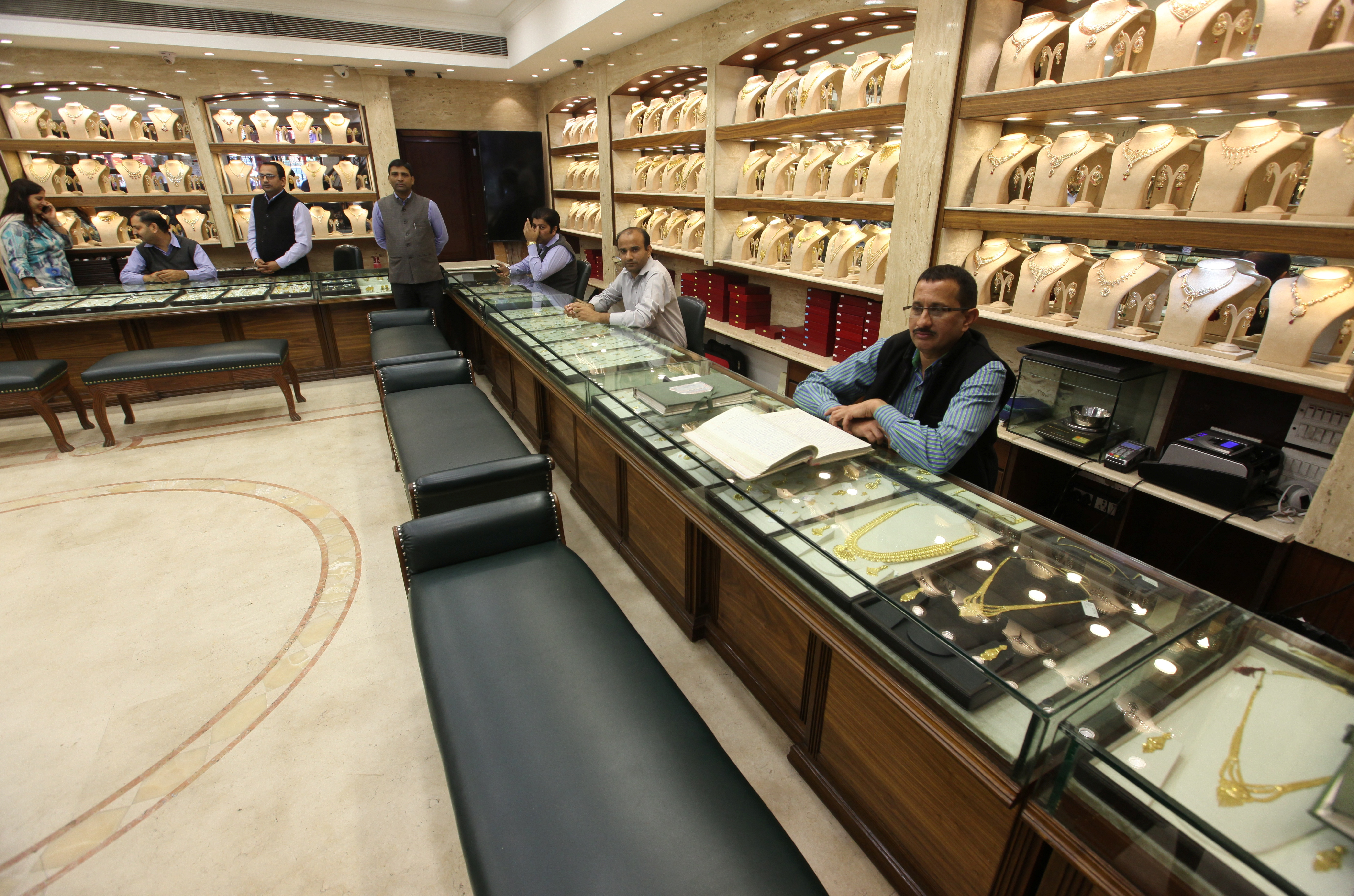 Sales persons wait for customers at a gold jewelry showroom in Chandigarh