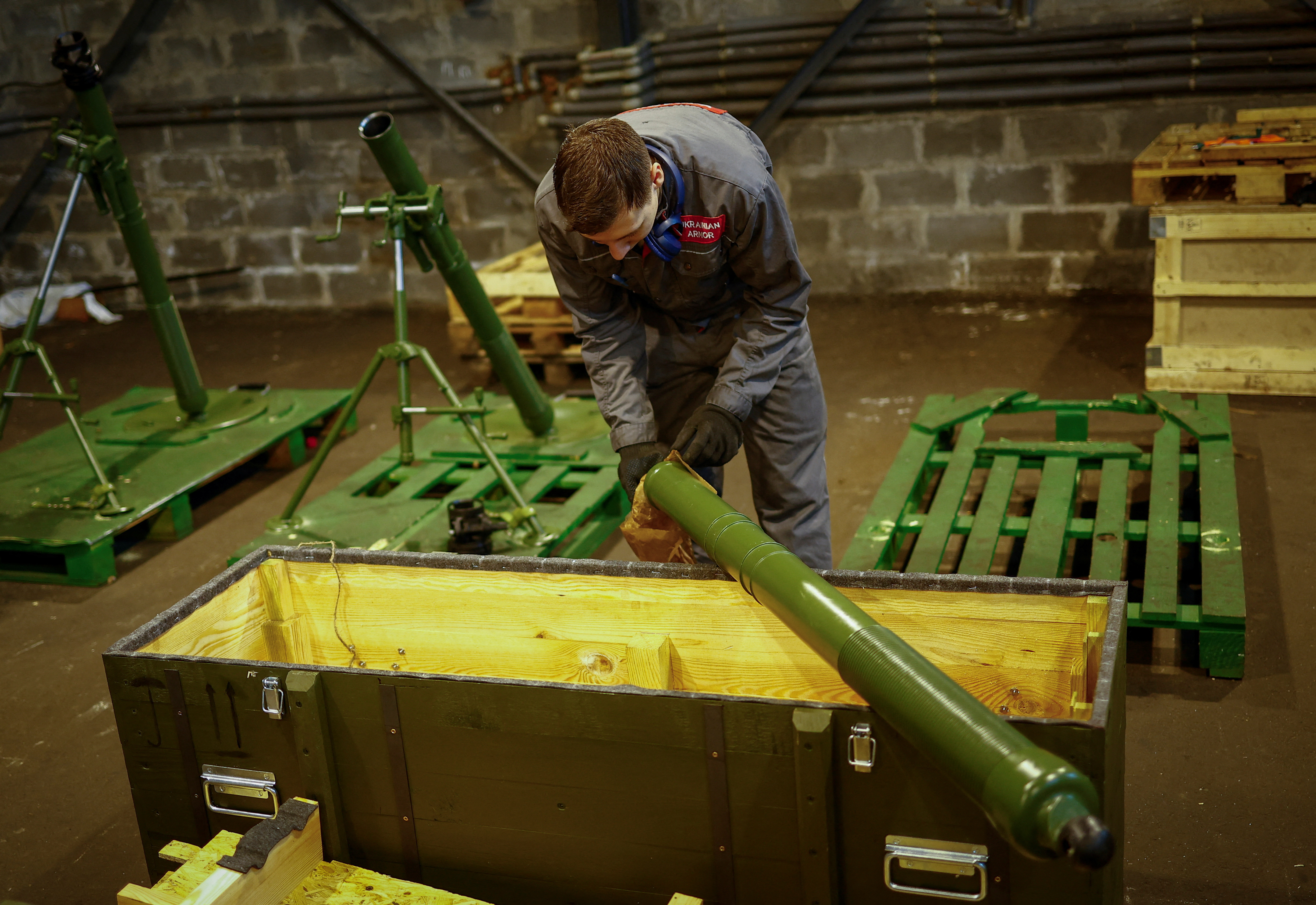 Employee prepares to place a mortar into a box at a production facility of the 'Ukrainian Armor' company in Ukraine