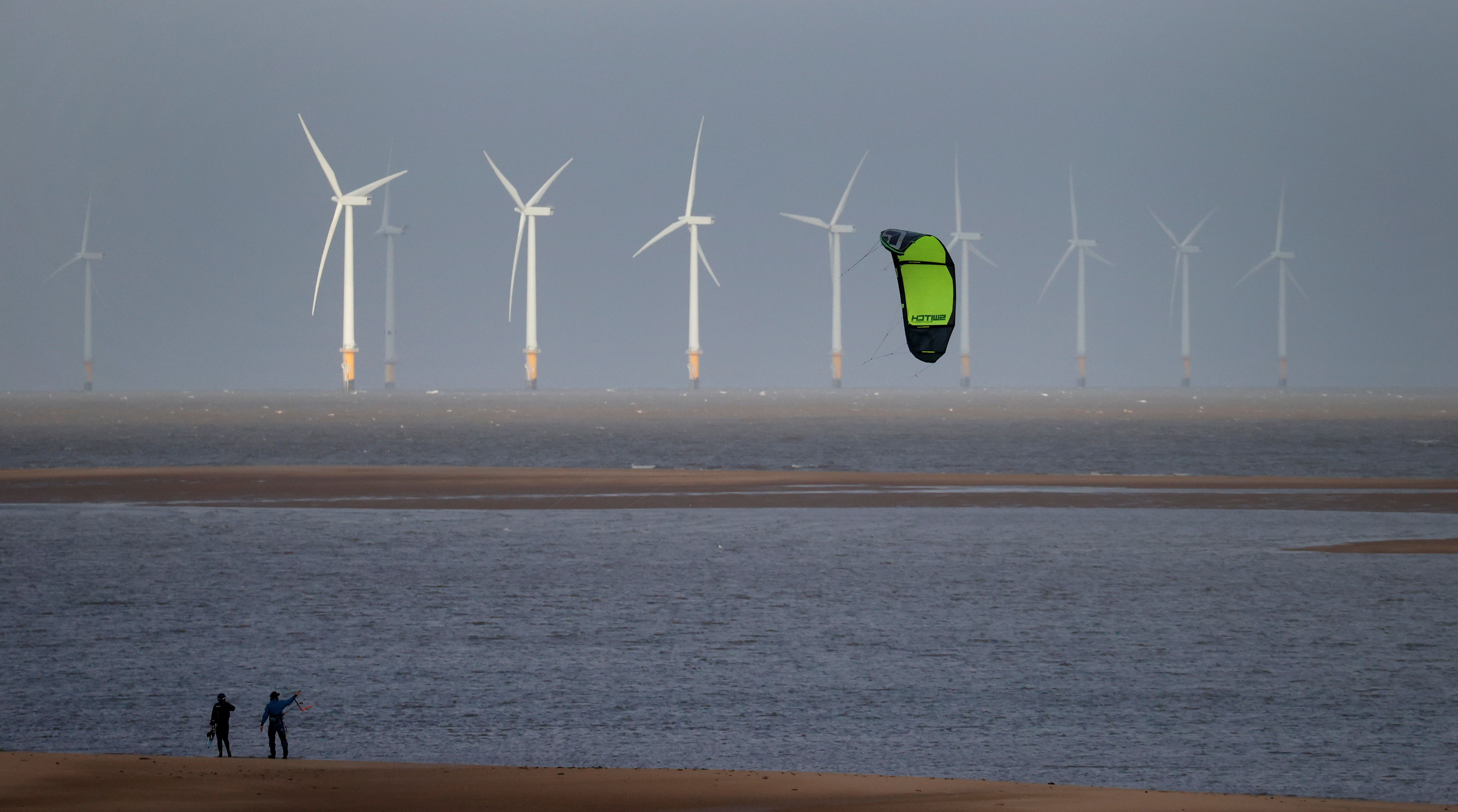 Kite surfers are pictured in front of the Burbo Bank offshore wind farm near New Brighton