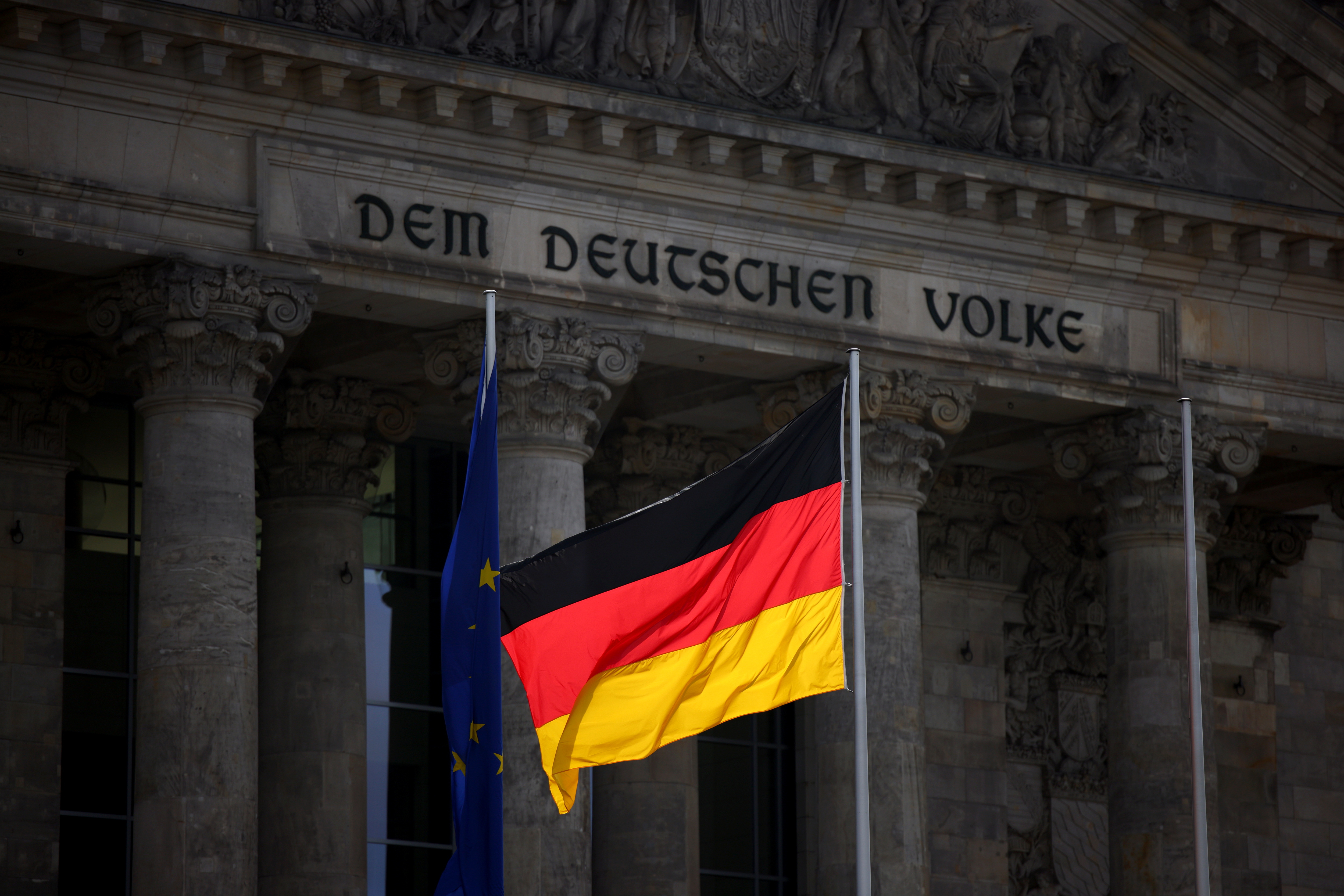 The German national flag flies in front of Reichstag building in Berlin
