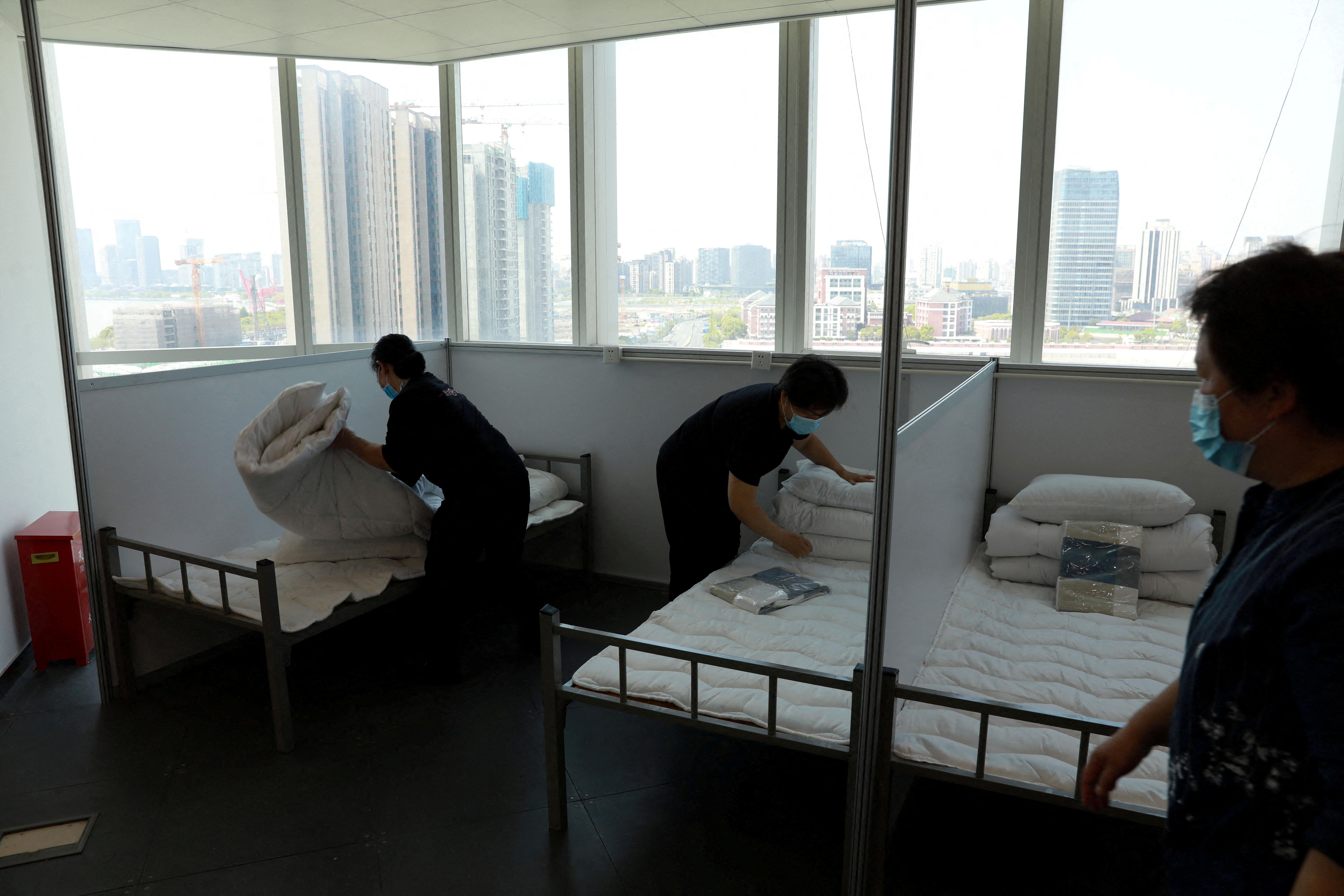 Workers convert an office building into a makeshift hospital in Shanghai
