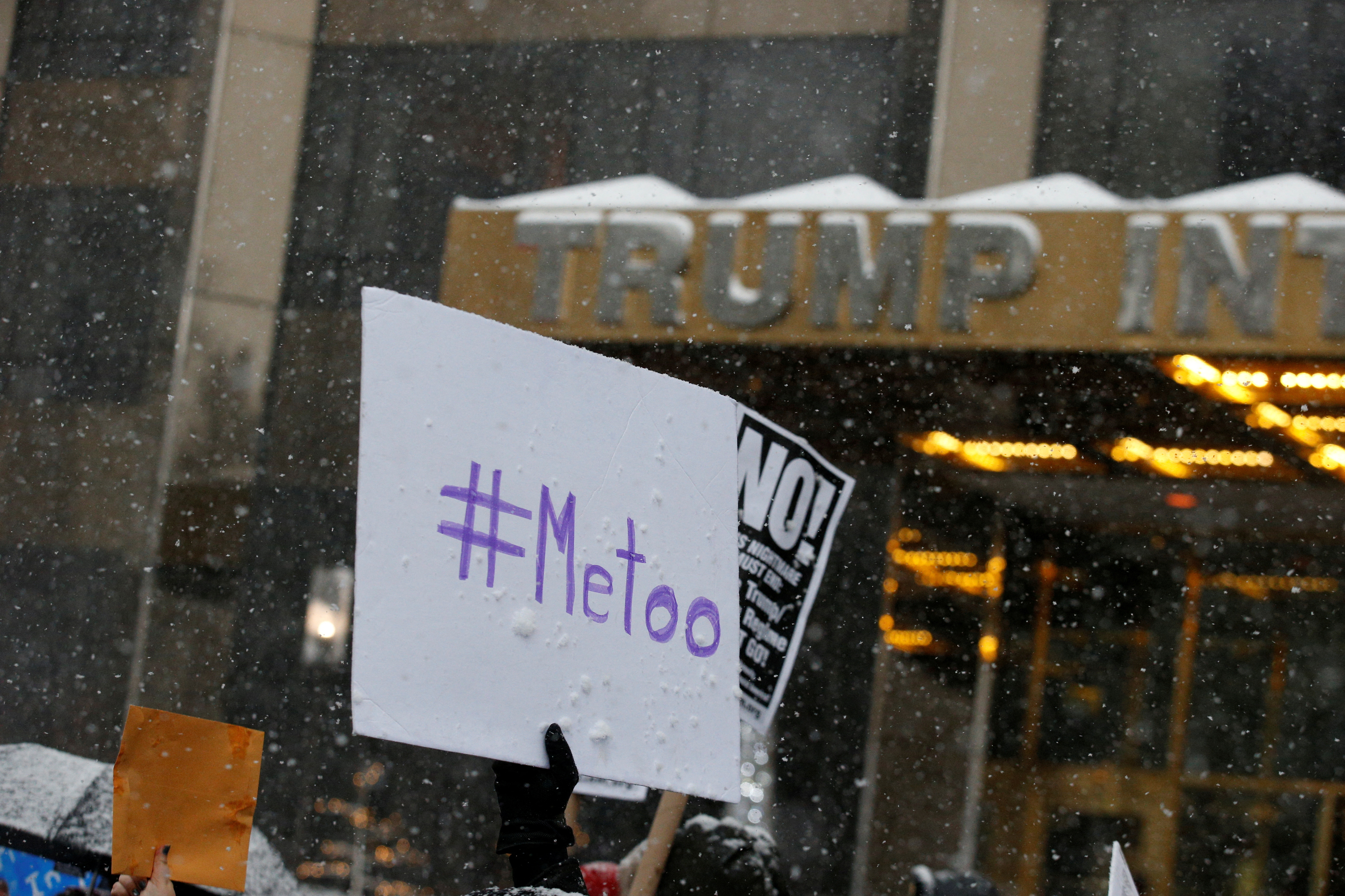 Protest signs are raised at #MeToo demonstration outside Trump International hotel in New York
