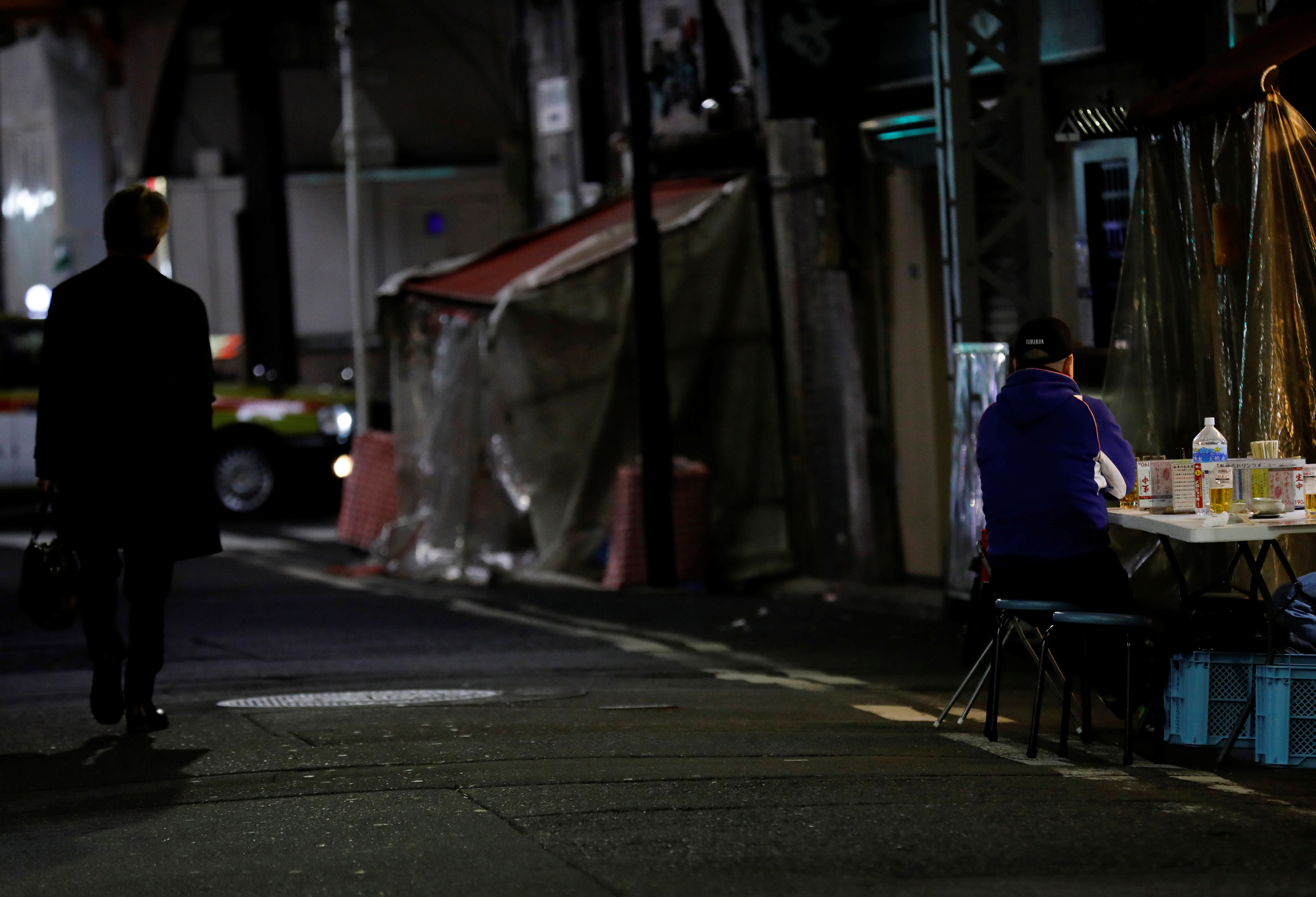 A man drinks at the table outside a bar which opens after 8 PM, the time the government asks restaurants and bars to close by, amid the coronavirus state of emergency in Tokyo, Japan, January 15, 2021. Picture taken January 15, 2021. REUTERS/Kim Kyung-Hoon
