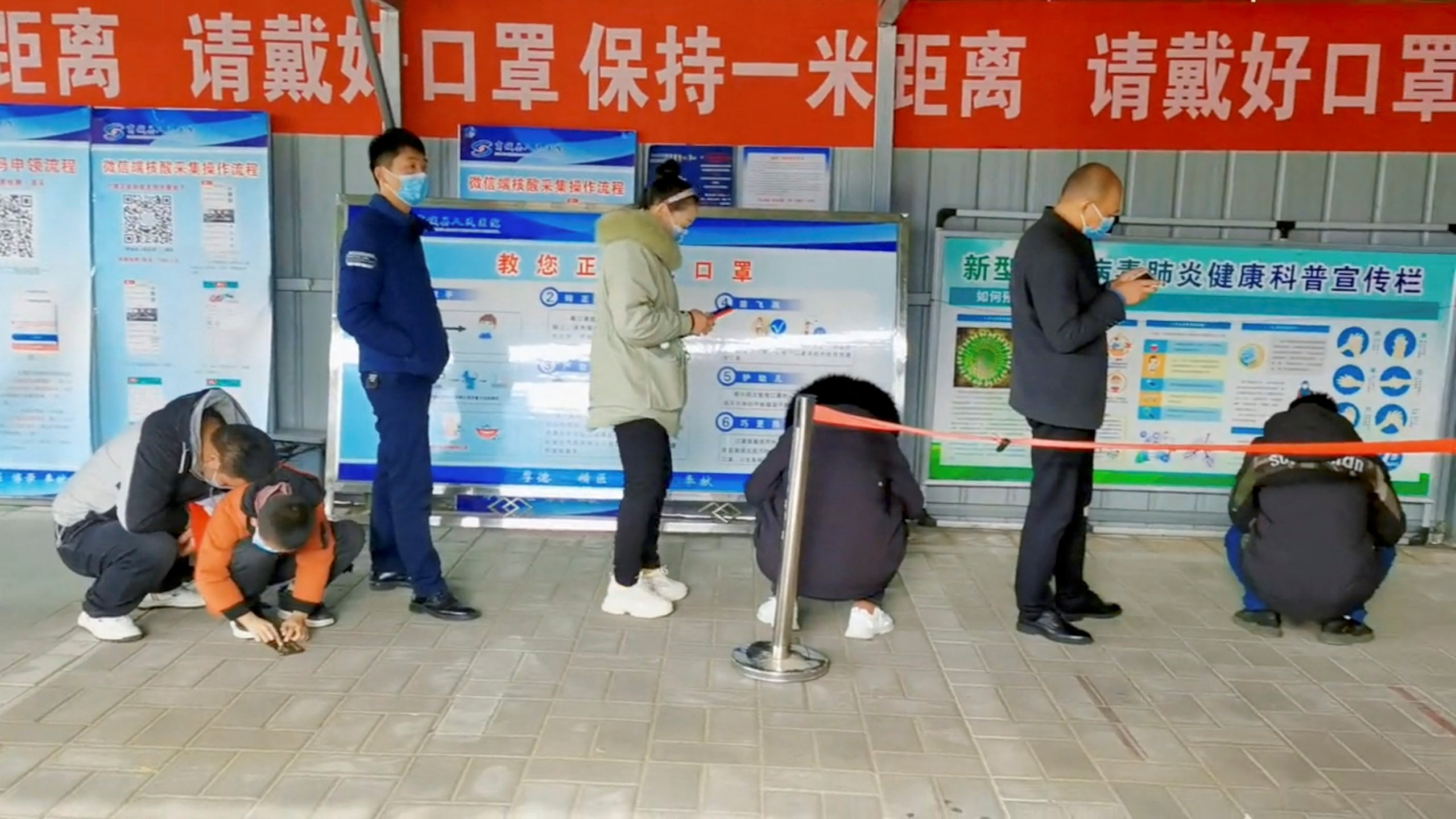 People wait in line at a coronavirus disease (COVID-19) test centre in Xinyang