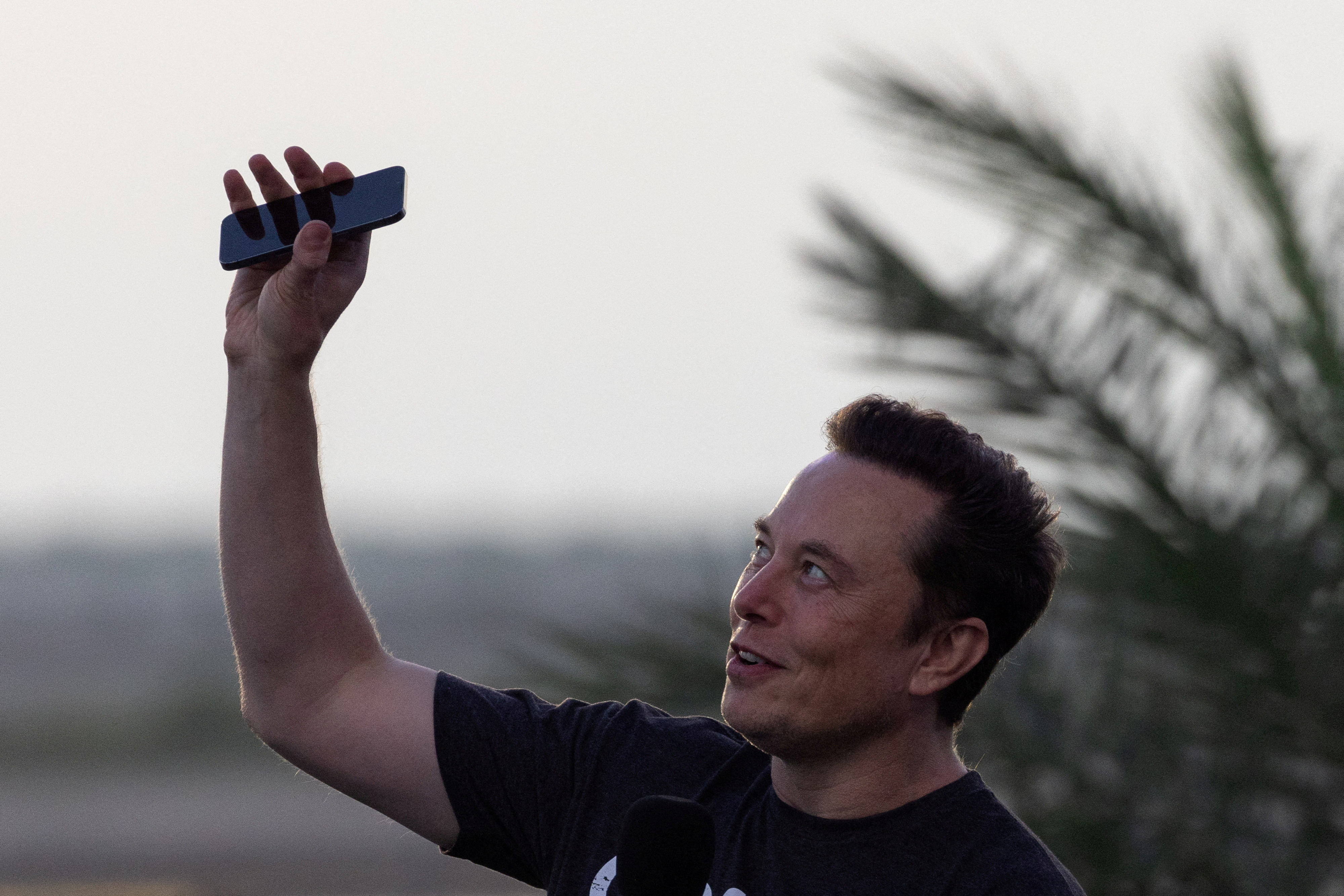 Musk raises phone towards the sky at SpaceX Starbase in Brownsville, Texas