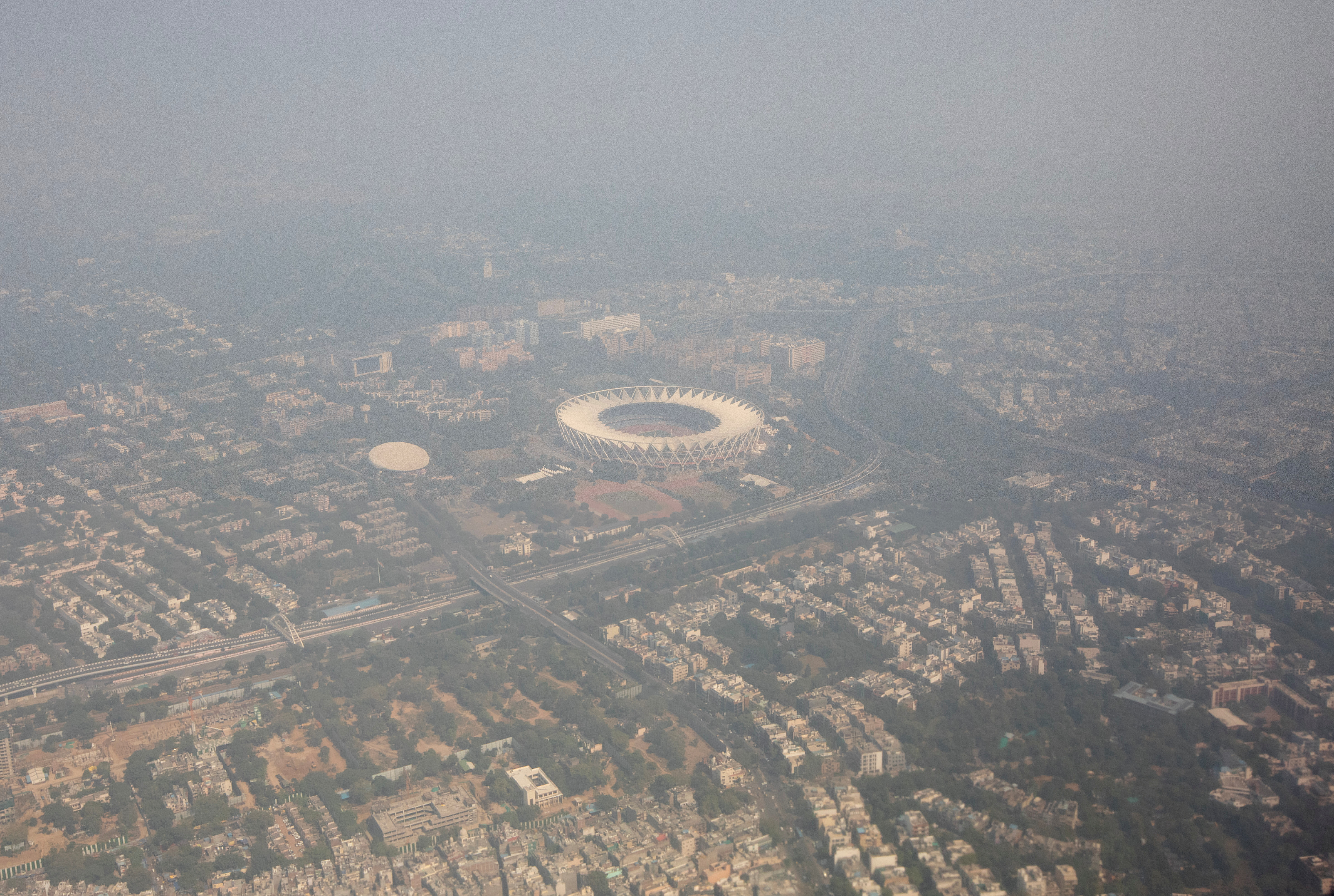 An aerial view shows residential buildings and a stadium shrouded in smog in New Delhi