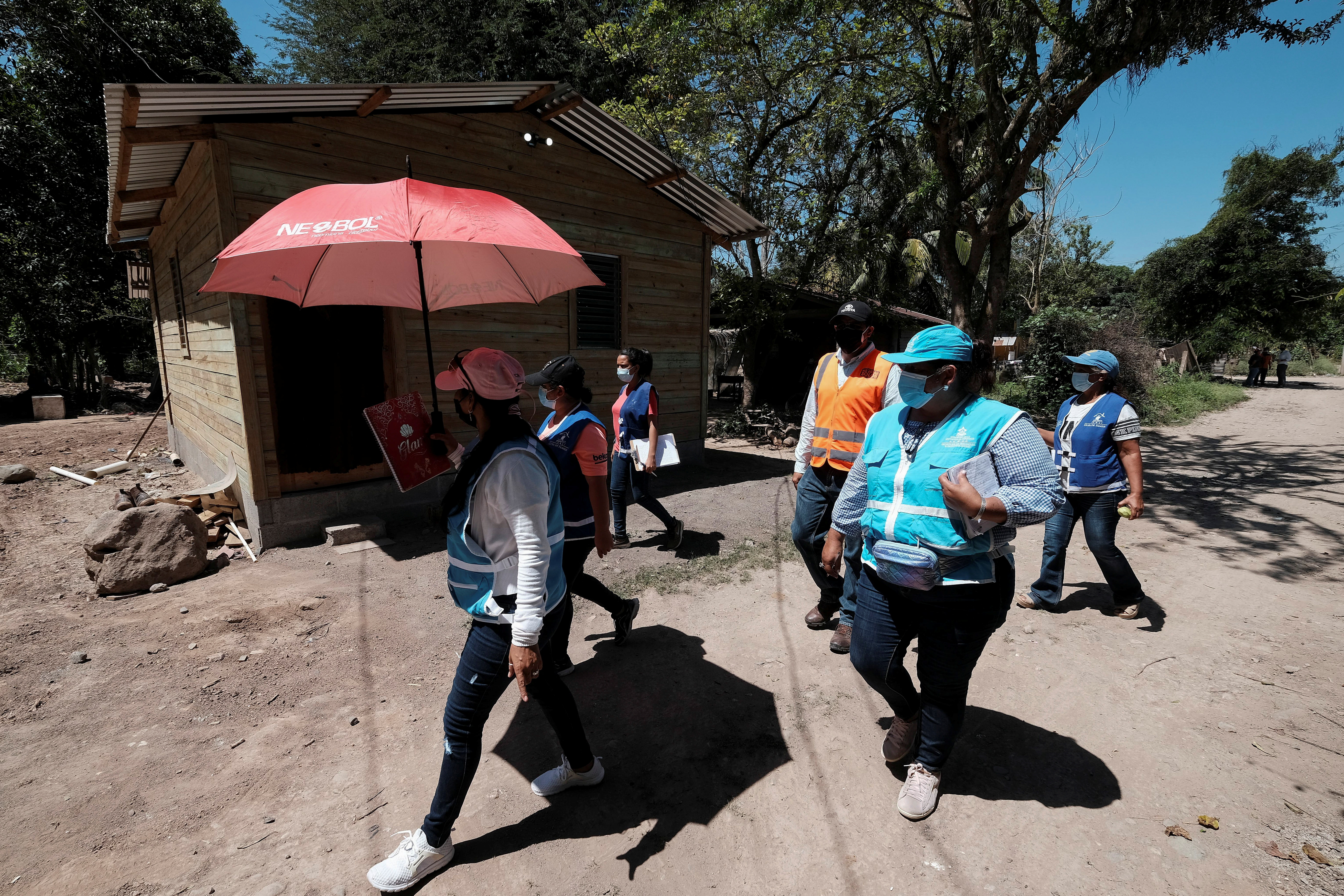 Activists from the ruling Partido Nacional (National Party) are seen at a neighborhood affected by the floods caused by hurricanes Eta and Iota, in El Progreso