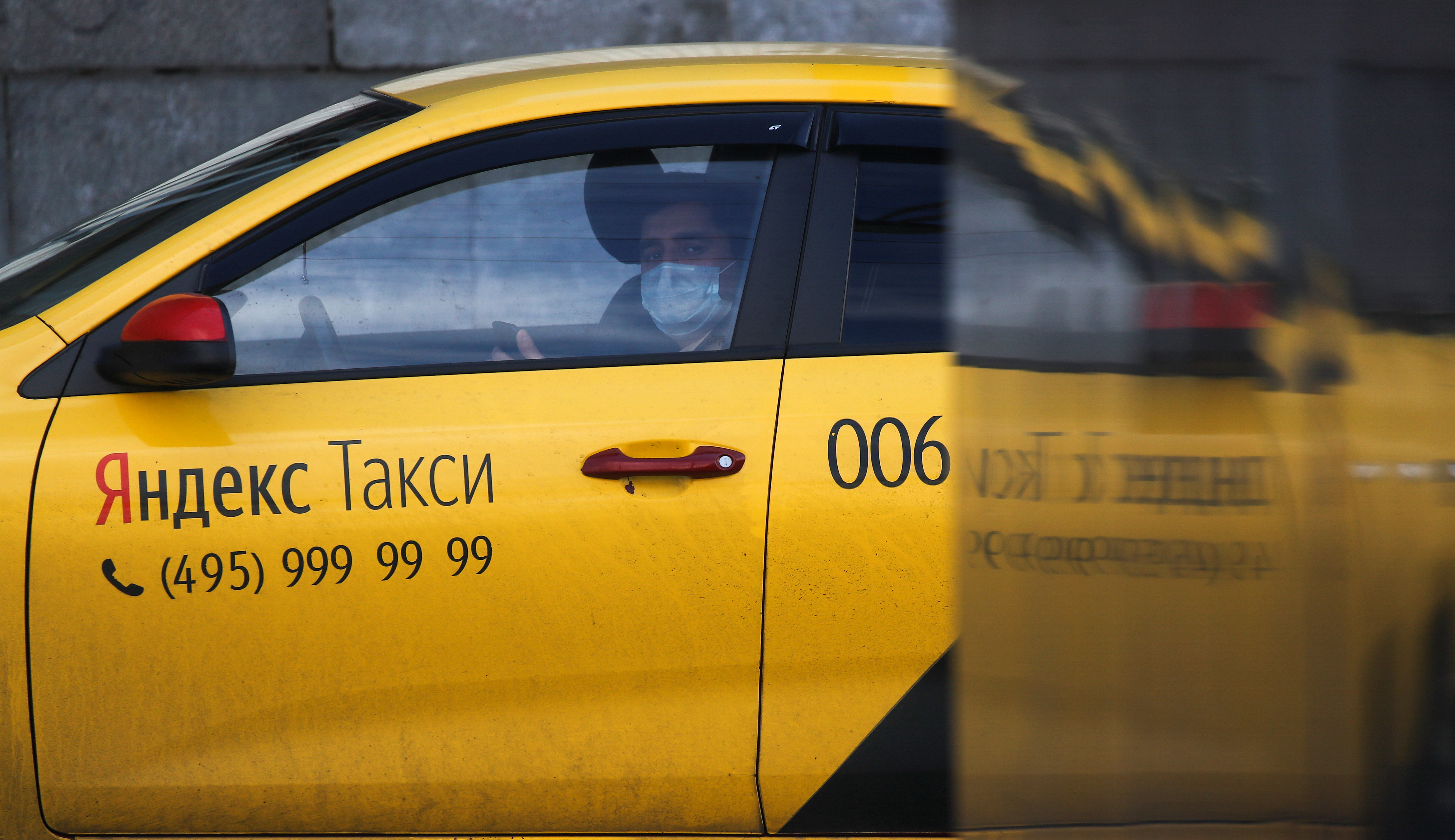 A driver of Yandex.Taxi online ride-sharing service sits inside a car in Moscow