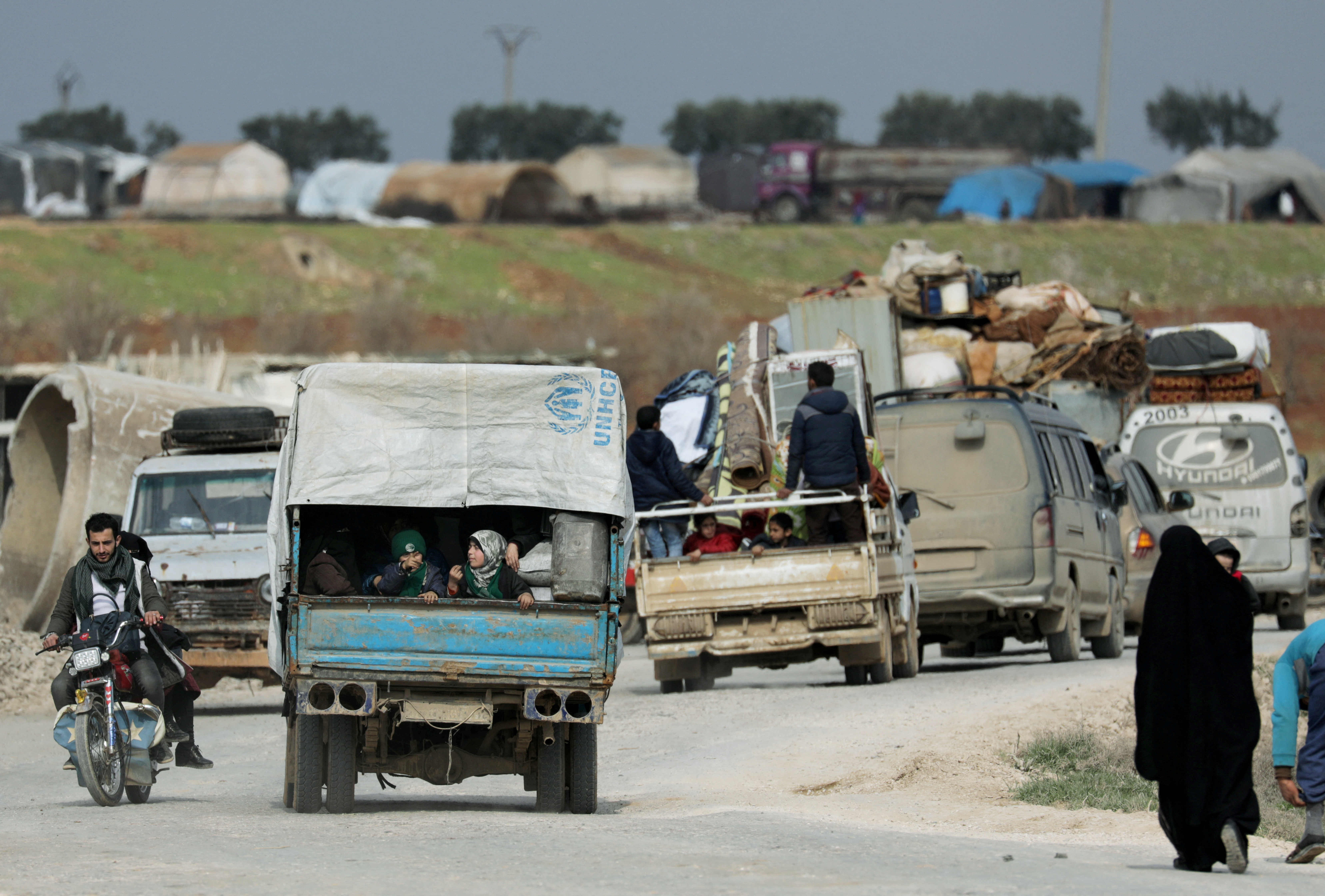Internally displaced people ride on trucks with their belongings in Afrin