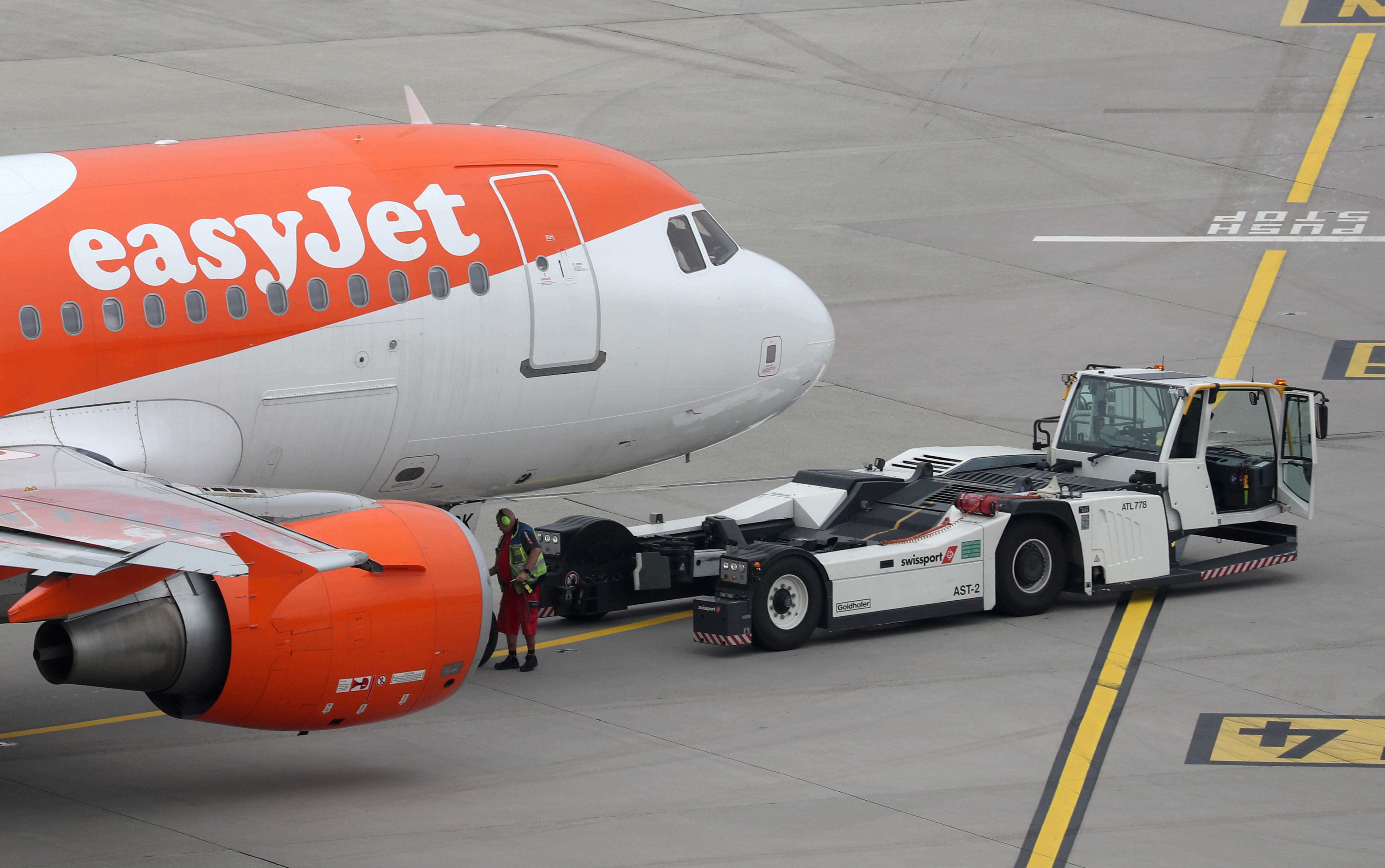 A Goldhofer pushback tractor of air services provider Swissport stands in front of an Easy Jet aircraft at Zurich Airport