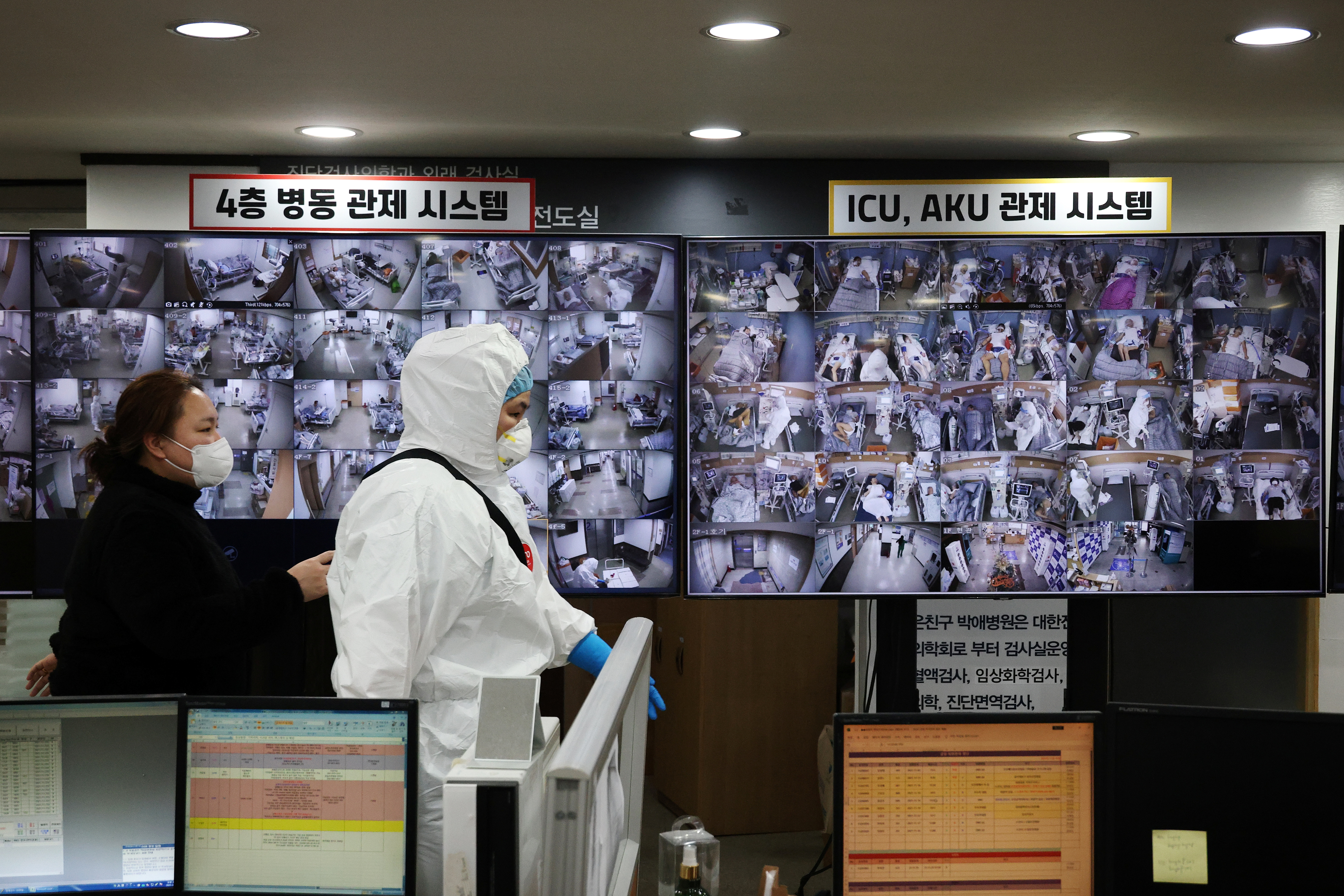 A medical worker walks past a screen monitoring coronavirus disease (COVID-19) patients at the intensive care unit (ICU) of Bagae Hospital in Pyeongtaek