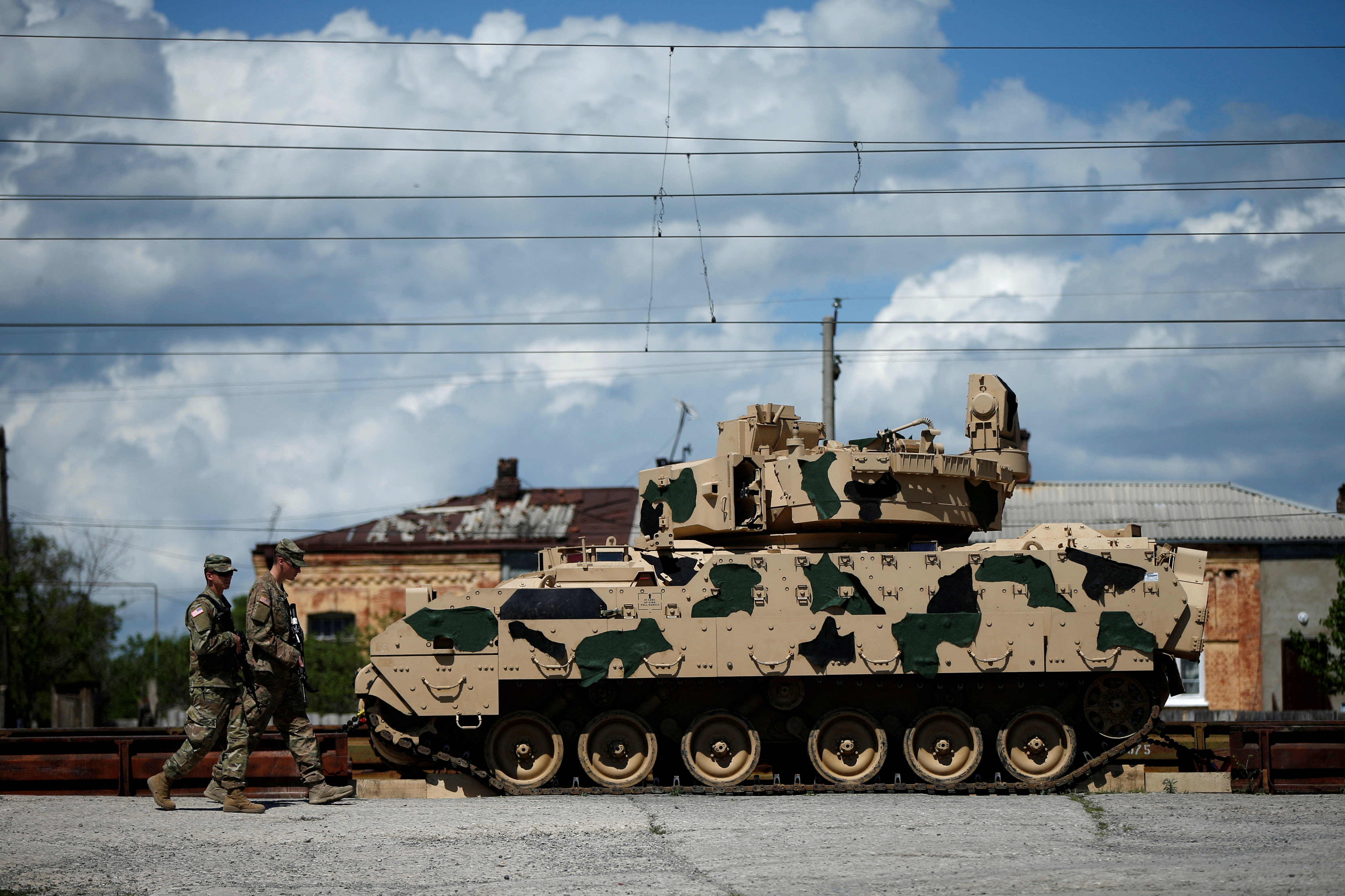 U.S. servicemen walk past a Bradley infantry fighting vehicle as they arrive for the joint U.S.-Georgian exercise Noble Partner 2016 in Vaziani