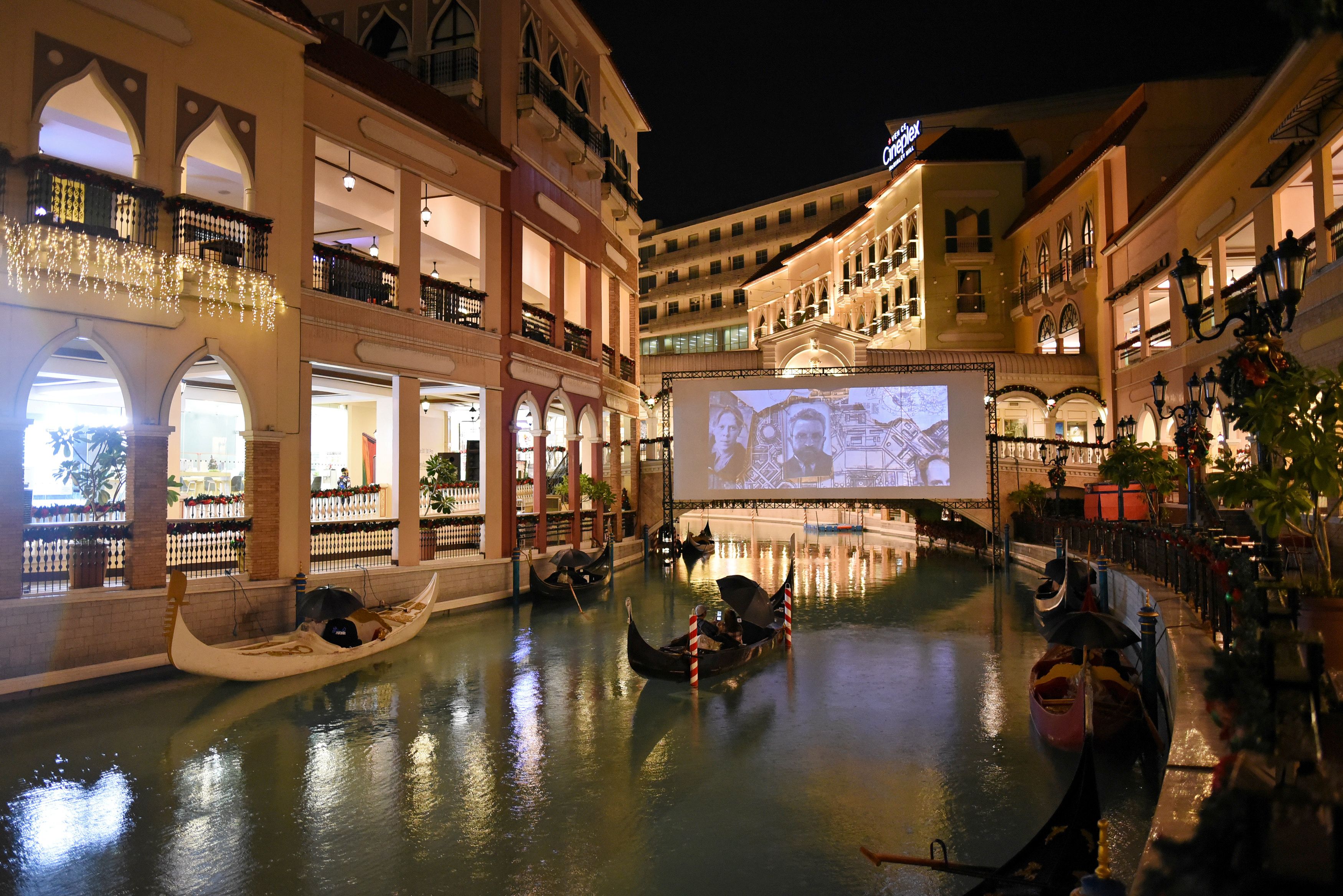 People on gondolas watch a movie while observing social distancing amid coronavirus disease (COVID-19) at a float-in cinema, in Venice Grand Canal Mall, Taguig City, Metro Manila