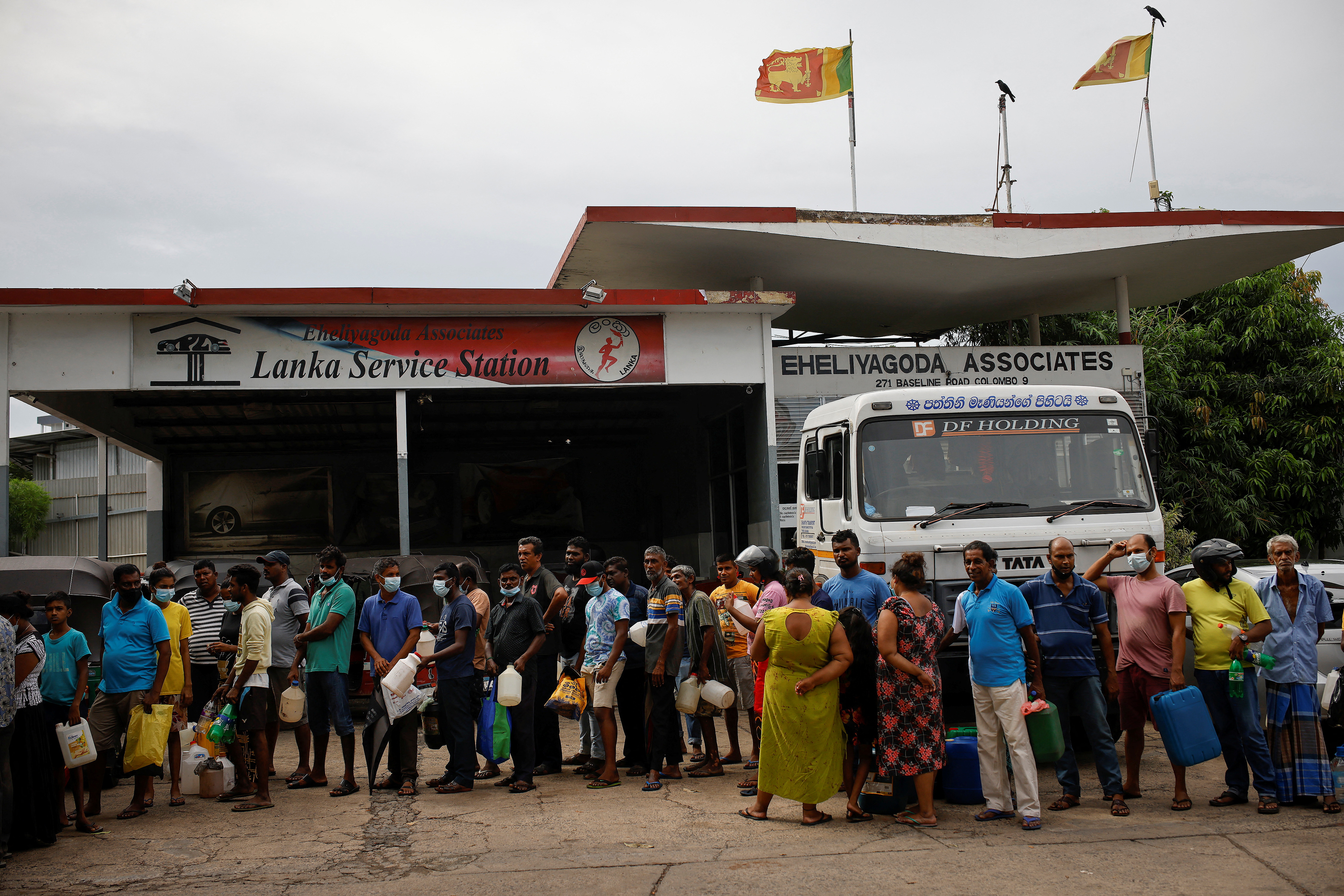 People wait in a queue to buy petrol at a fuel station, amid the country's economic crisis in Colombo