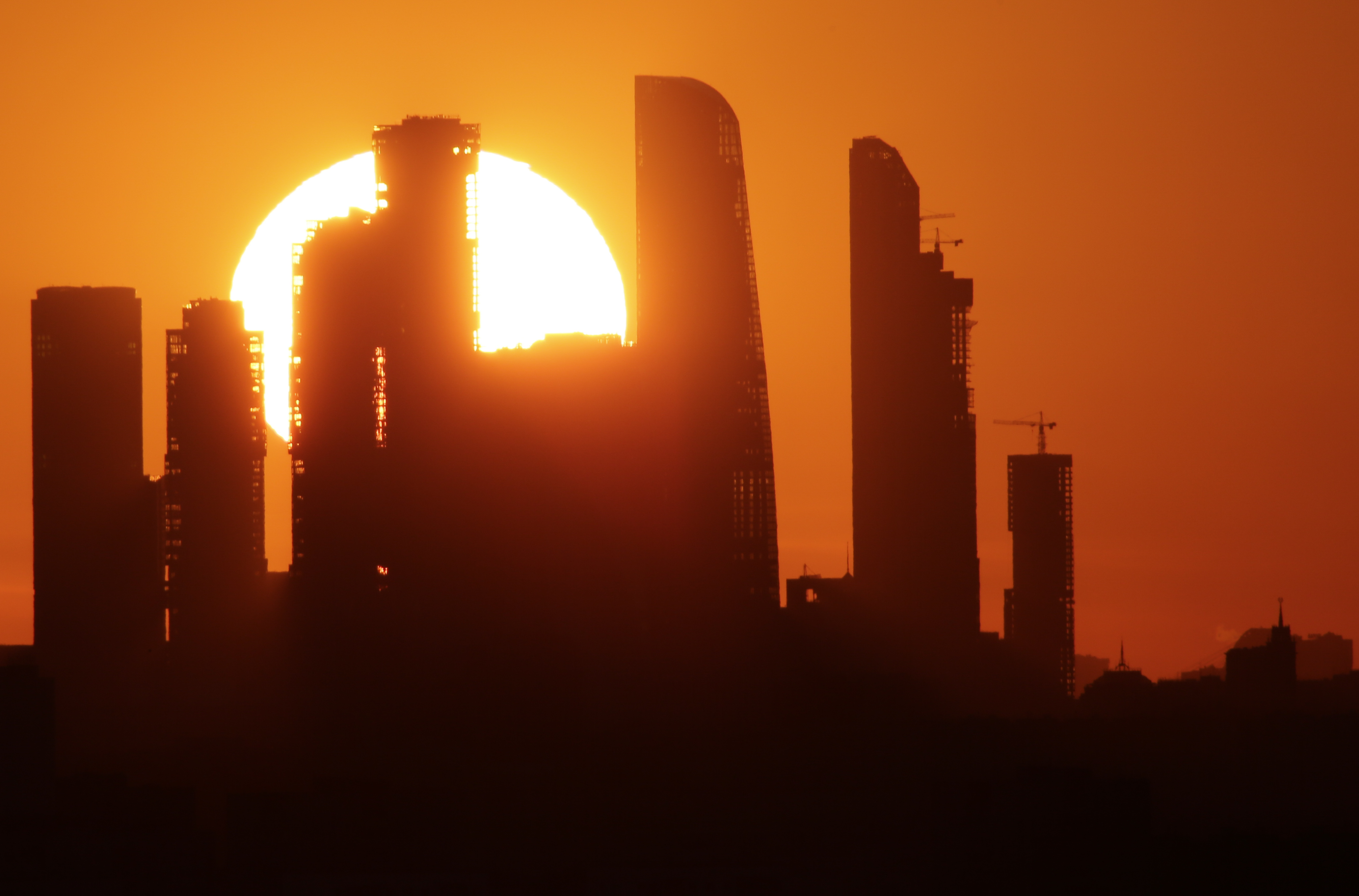 The sun sets behind the skyscrapers of the Moscow International Business Centre in Moscow