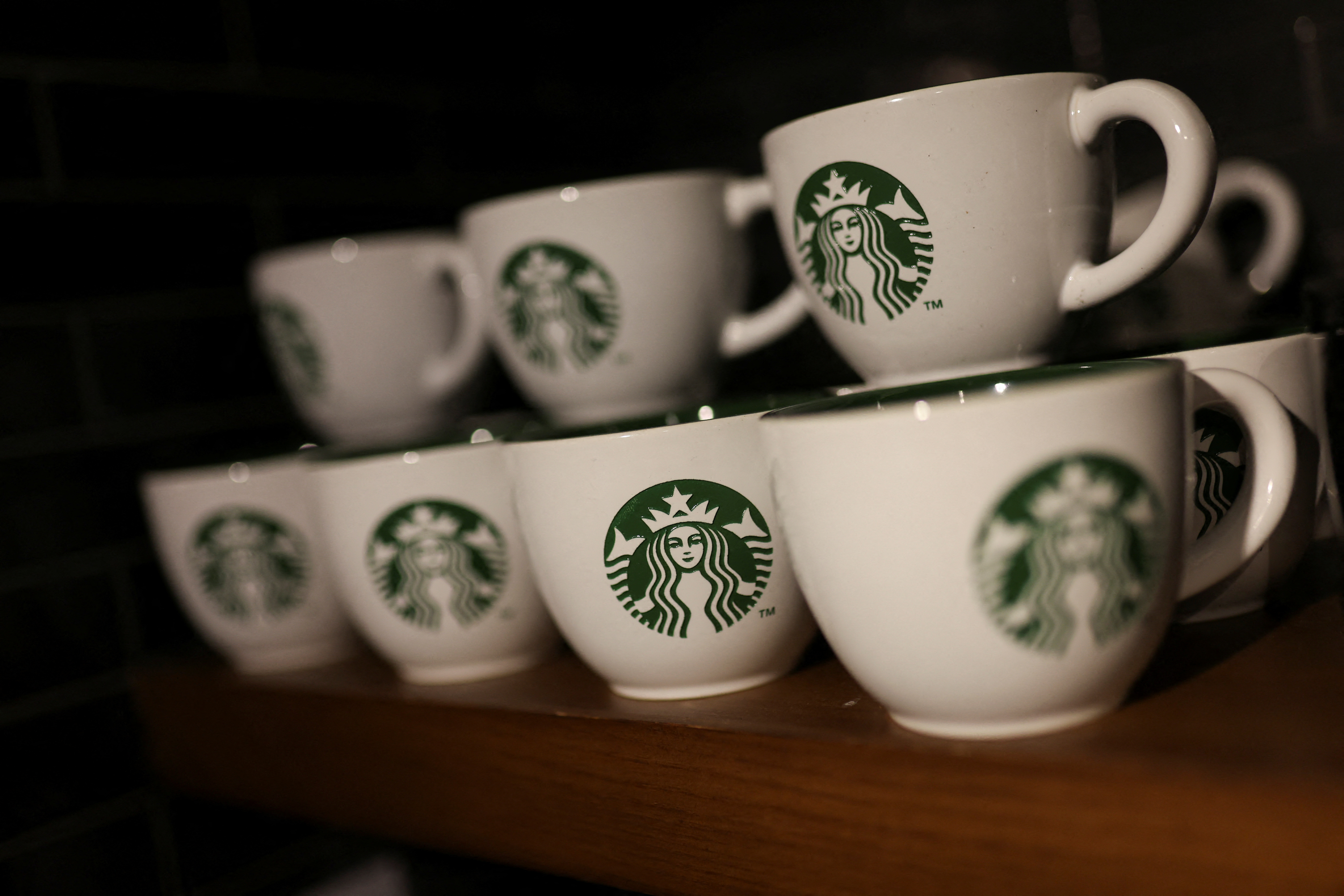 Branded coffee mugs are displayed in Starbucks' outlet at a market in New Delhi