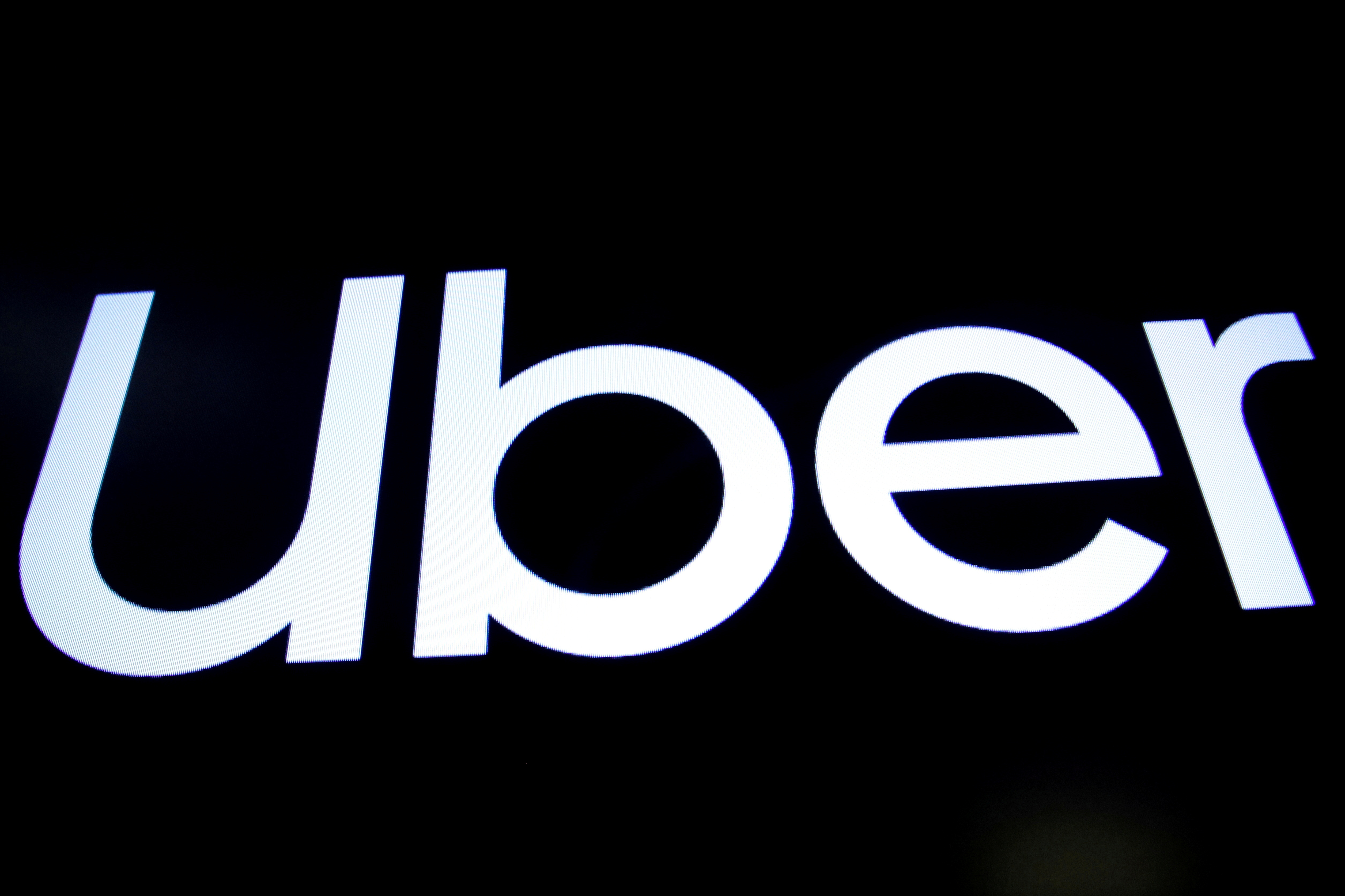 A screen displays the company logo of Uber Technologies Inc in New York