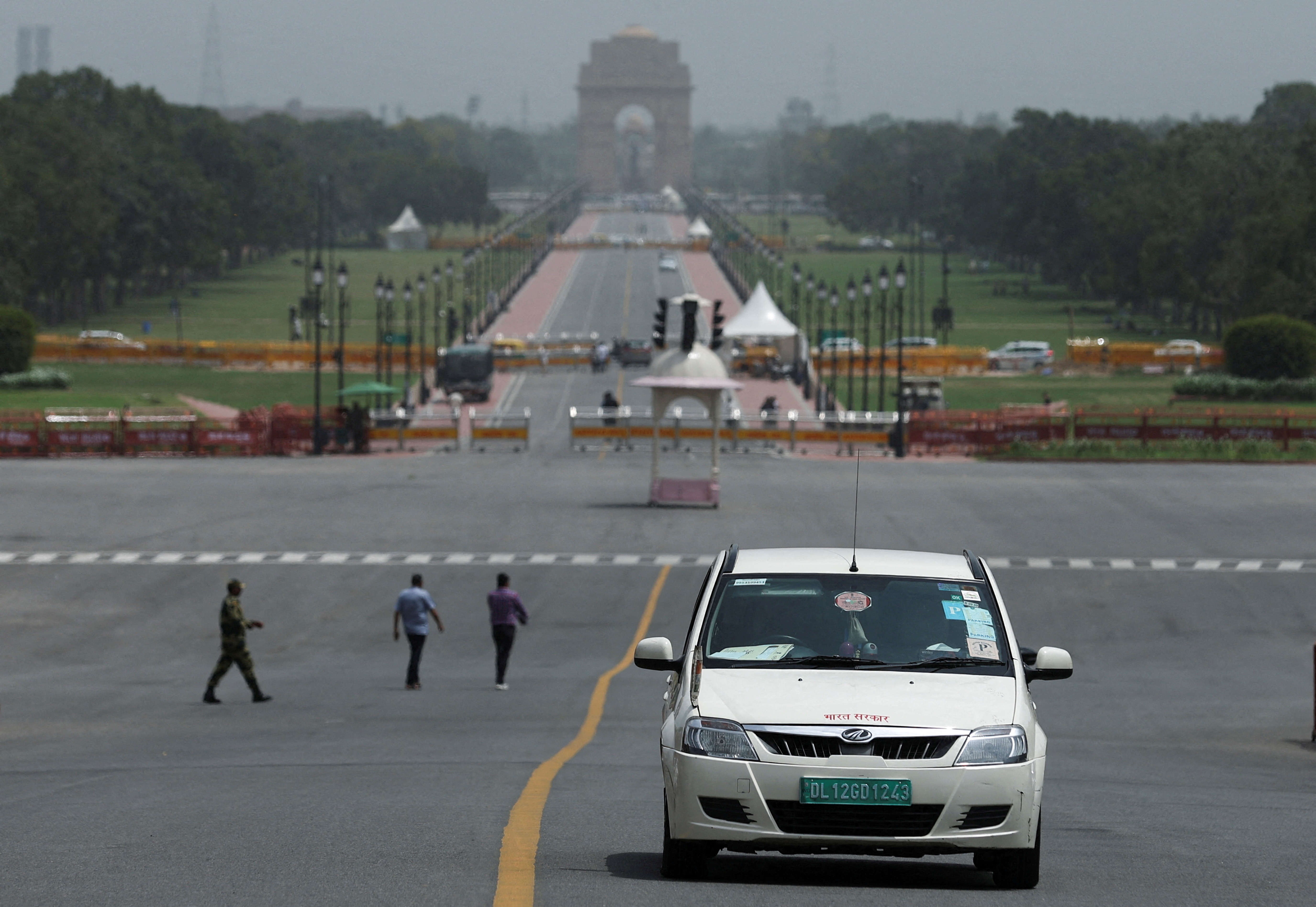 An electric vehicle is driven on the road near India Gate in New Delhi