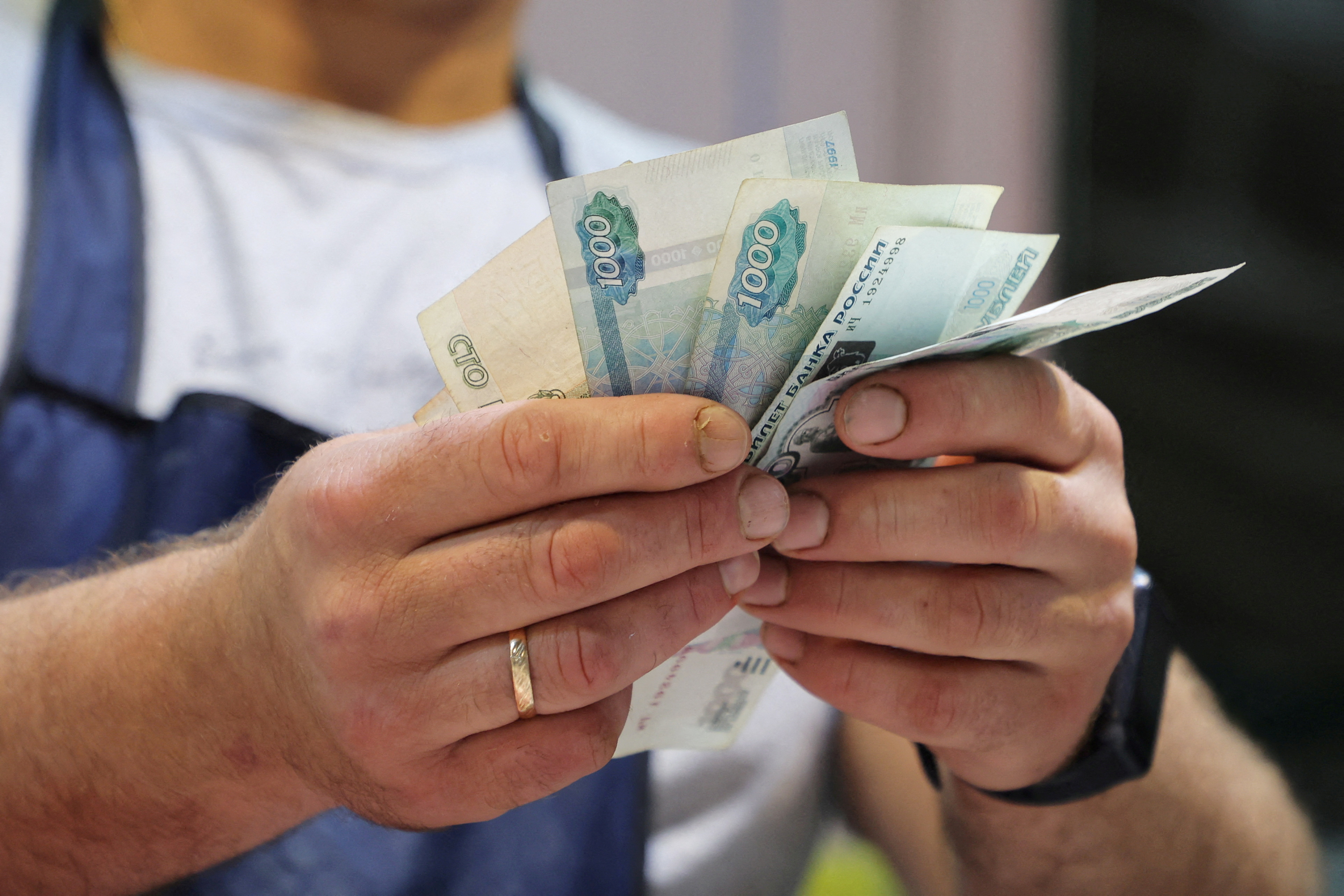 A vendor counts Russian rouble banknotes at a market in Saint Petersburg