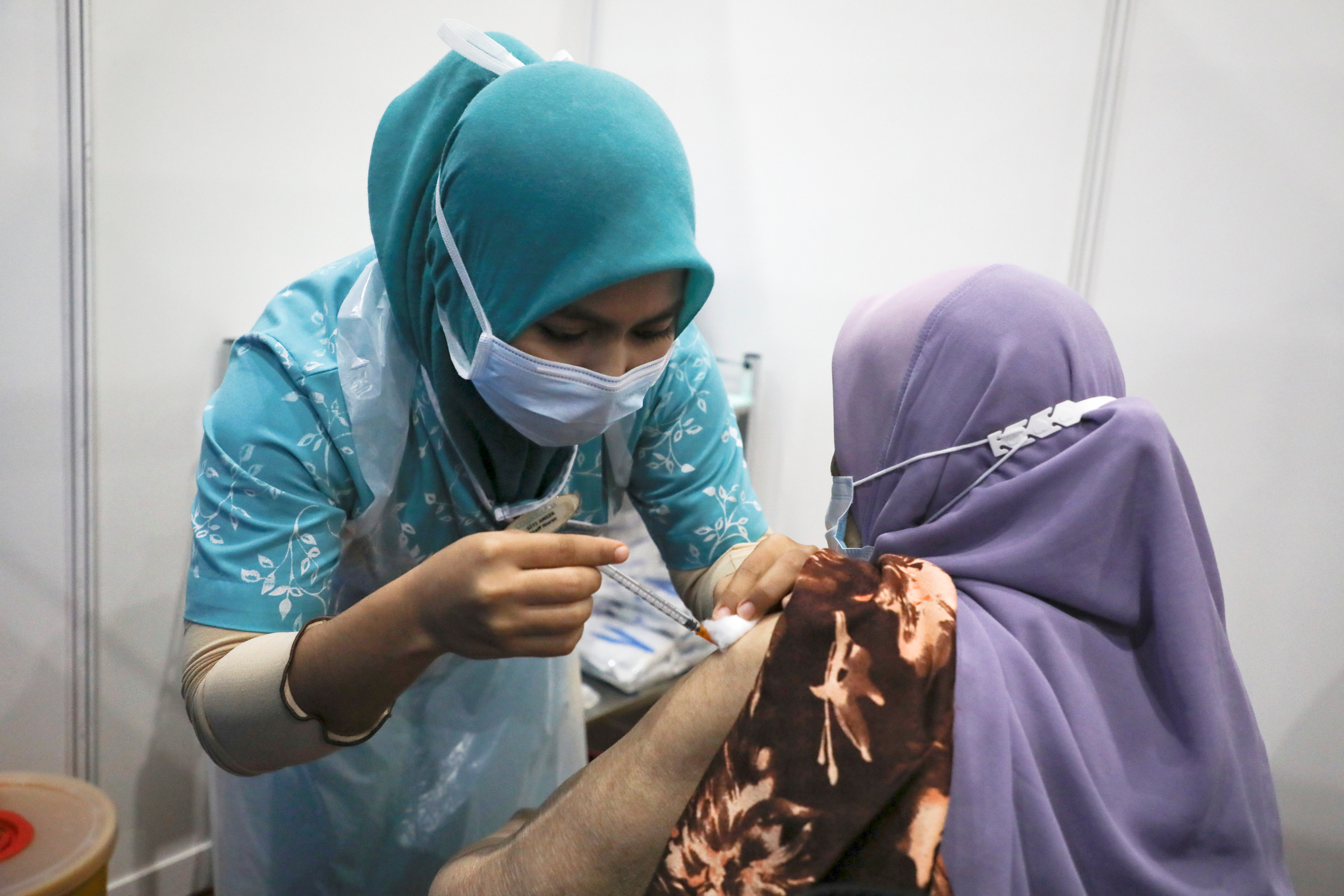 A woman receives a vaccine for the coronavirus disease (COVID-19), at a vaccination centre in Subang Jaya