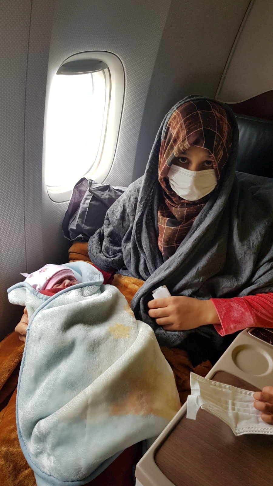 Afghan evacuee Soman Noori holds her newborn baby girl named Havva on board an evacuation flight operated by Turkish Airlines from Dubai to Britain's Birmingham, August 28, 2021. Turkish Airlines/Handout via REUTERS