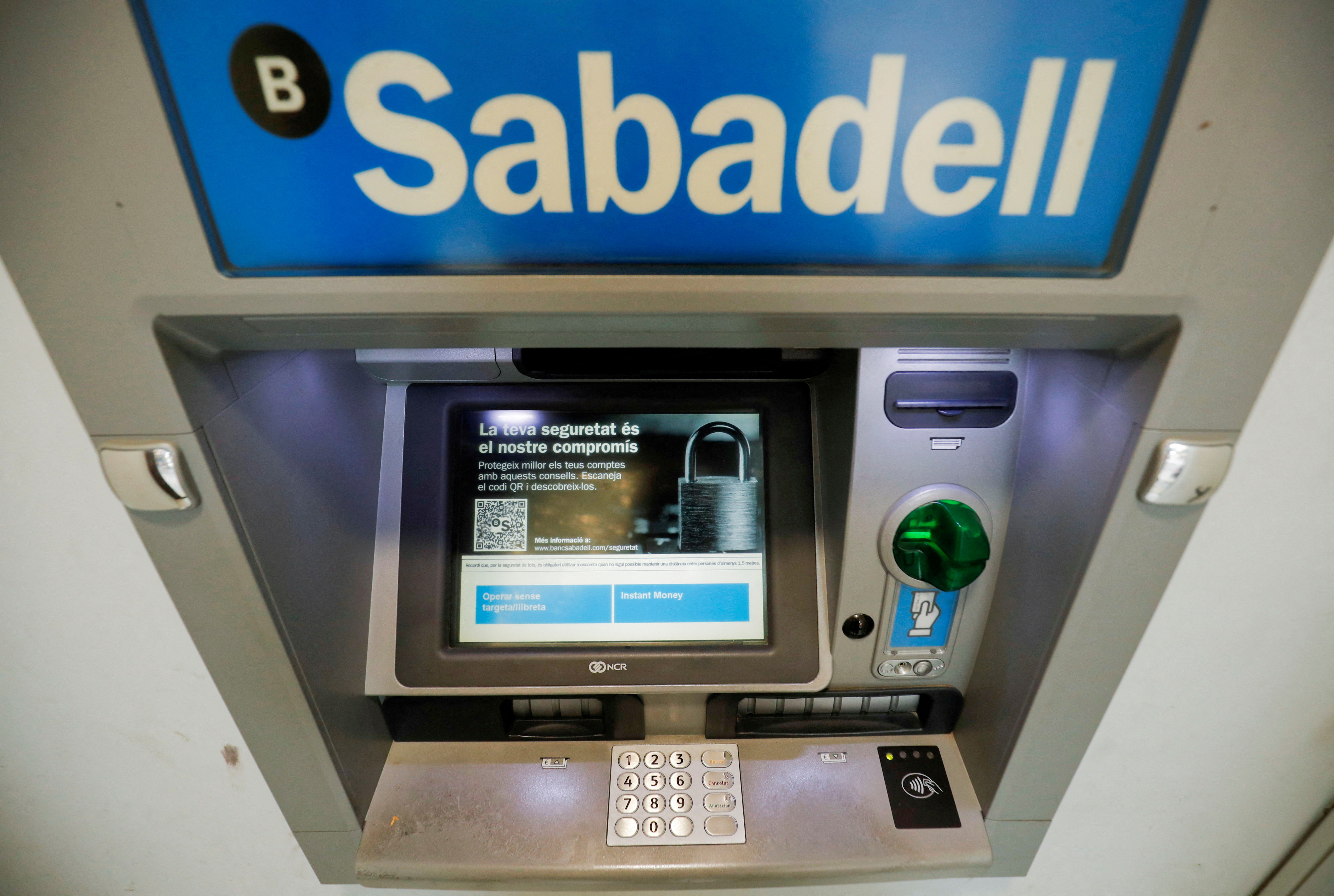 Sabadell bank's logo is seen at an ATM machine outside an office in Barcelona, Spain
